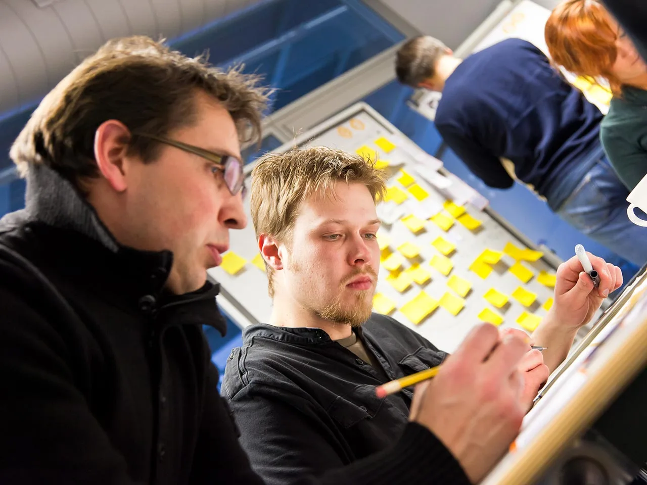 BMW participants sketching car interior concepts at a board covered in sticky notes