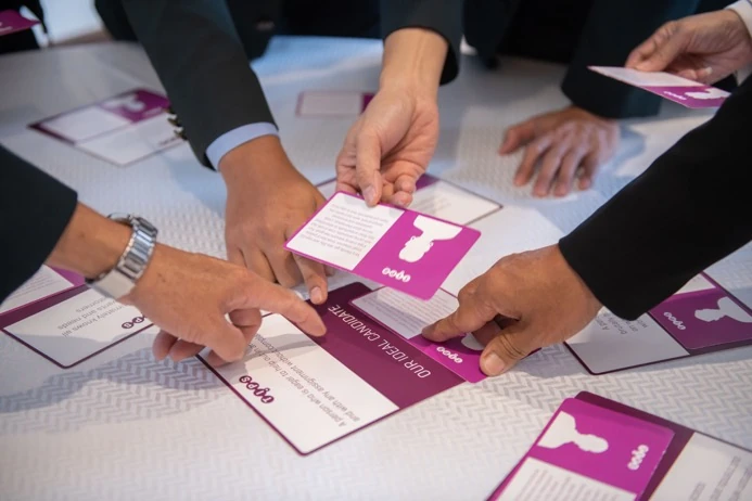 Hands sorting TIPS profile cards on a table