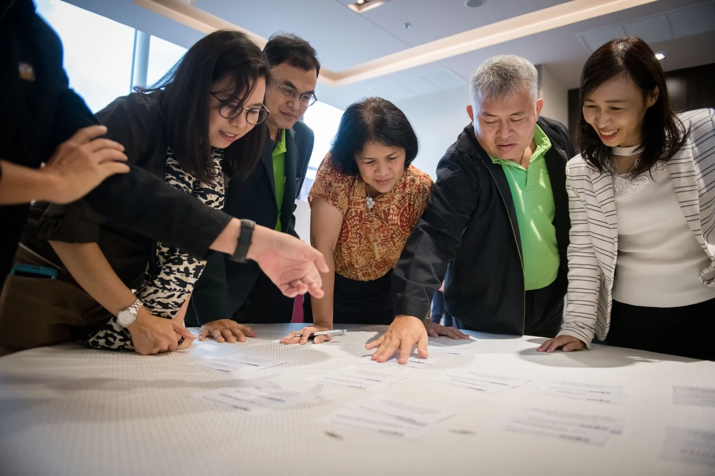 Delegates working together over worksheets at a table