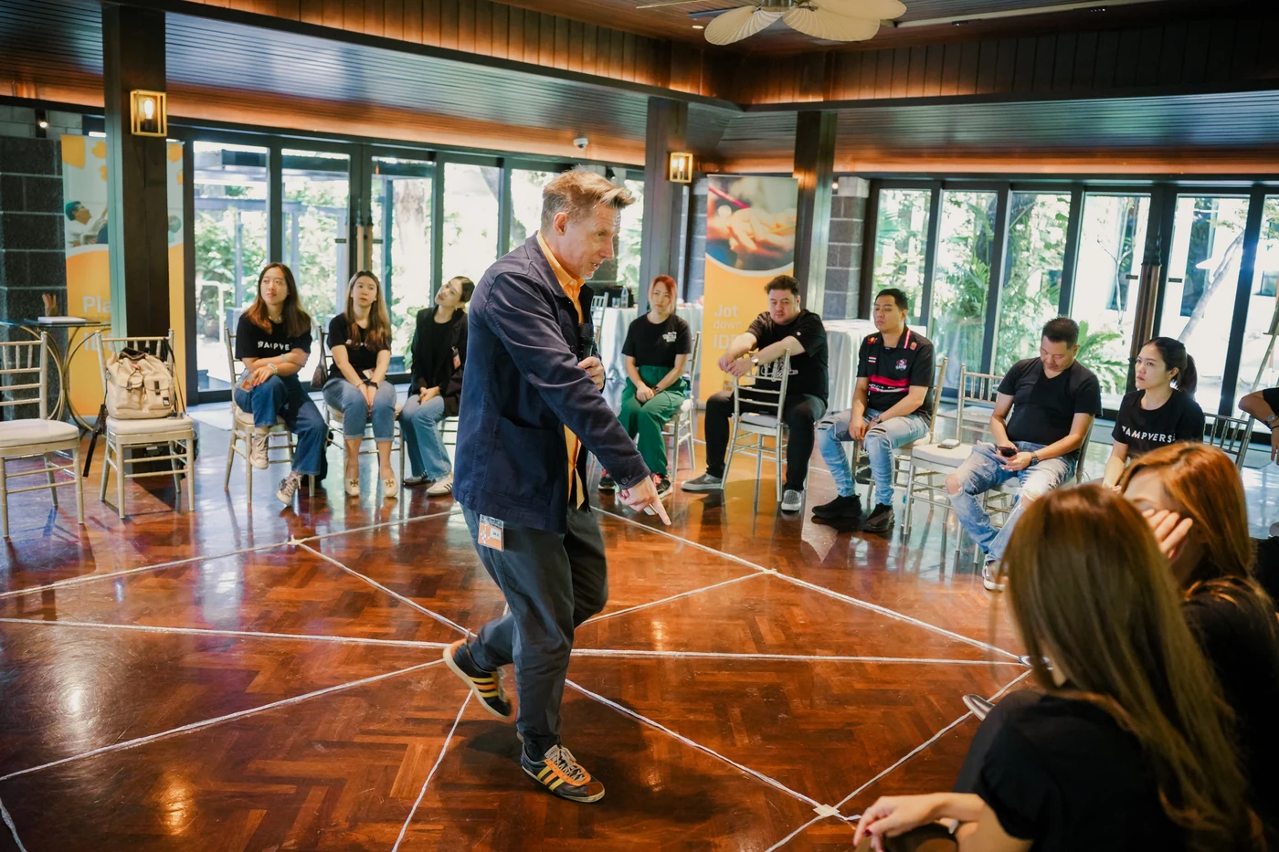 Dr. D on the TIPS floor map explaining an exercise to the Ampverse team