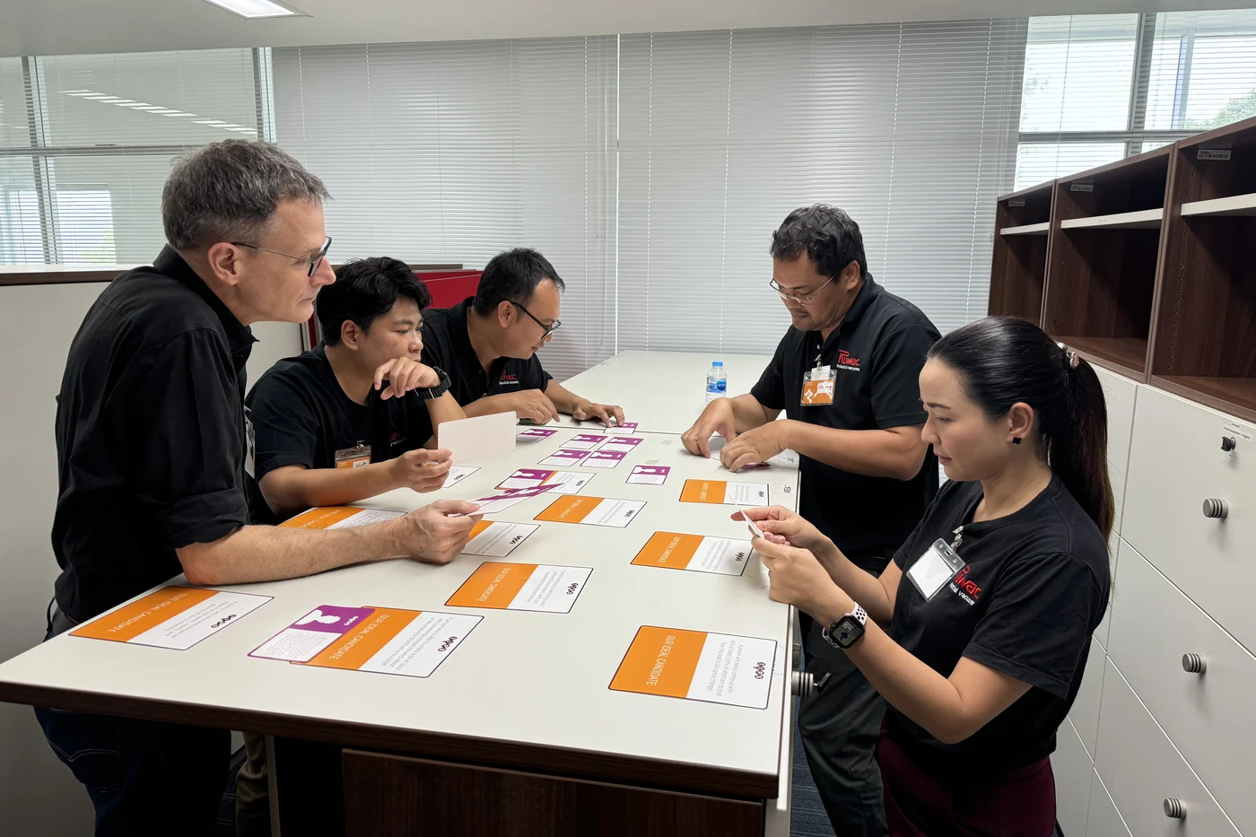 Ruwac Asia team members sorting TIPS cards at a table