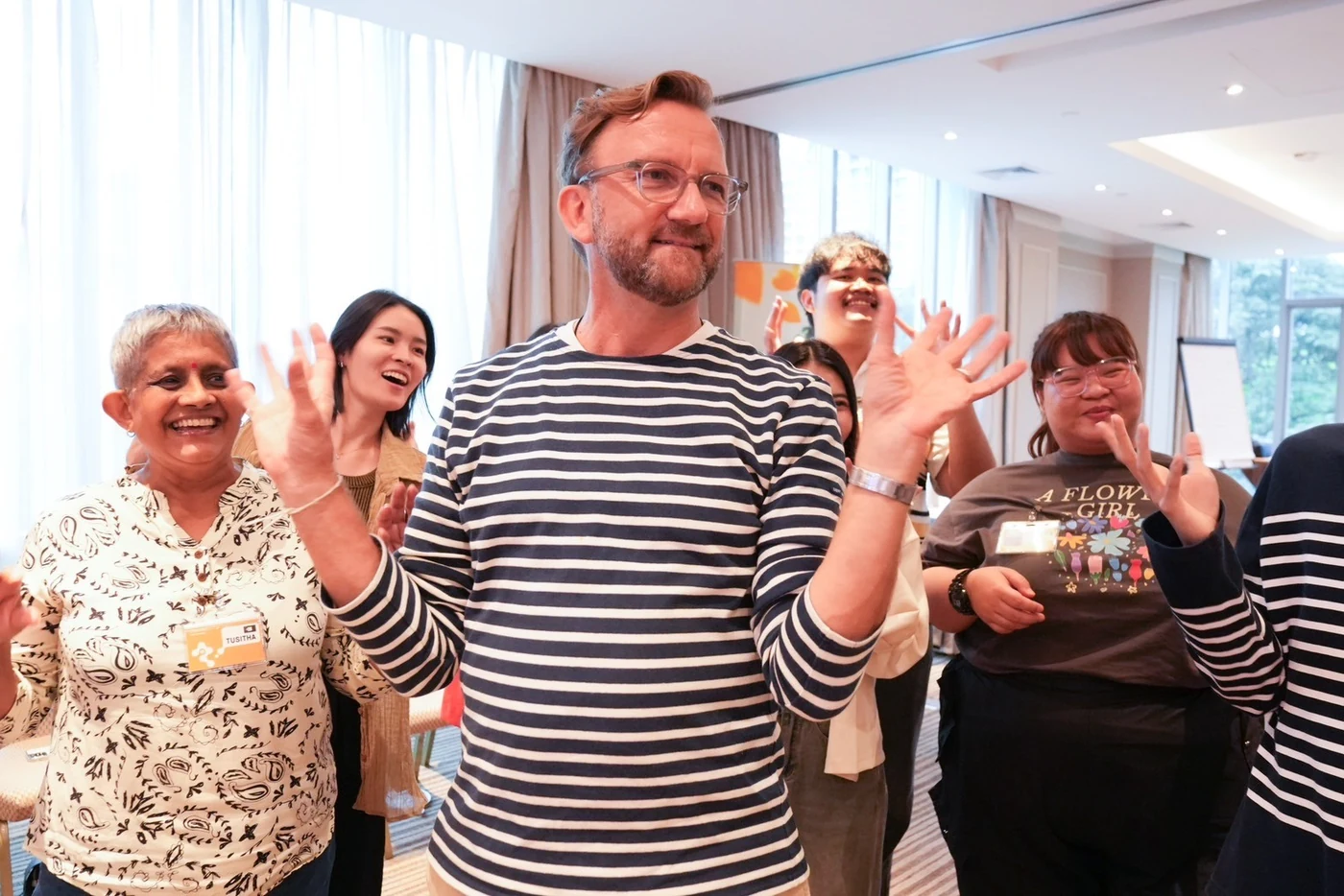 Square 44 team members laughing with raised hands during a TIPS exercise
