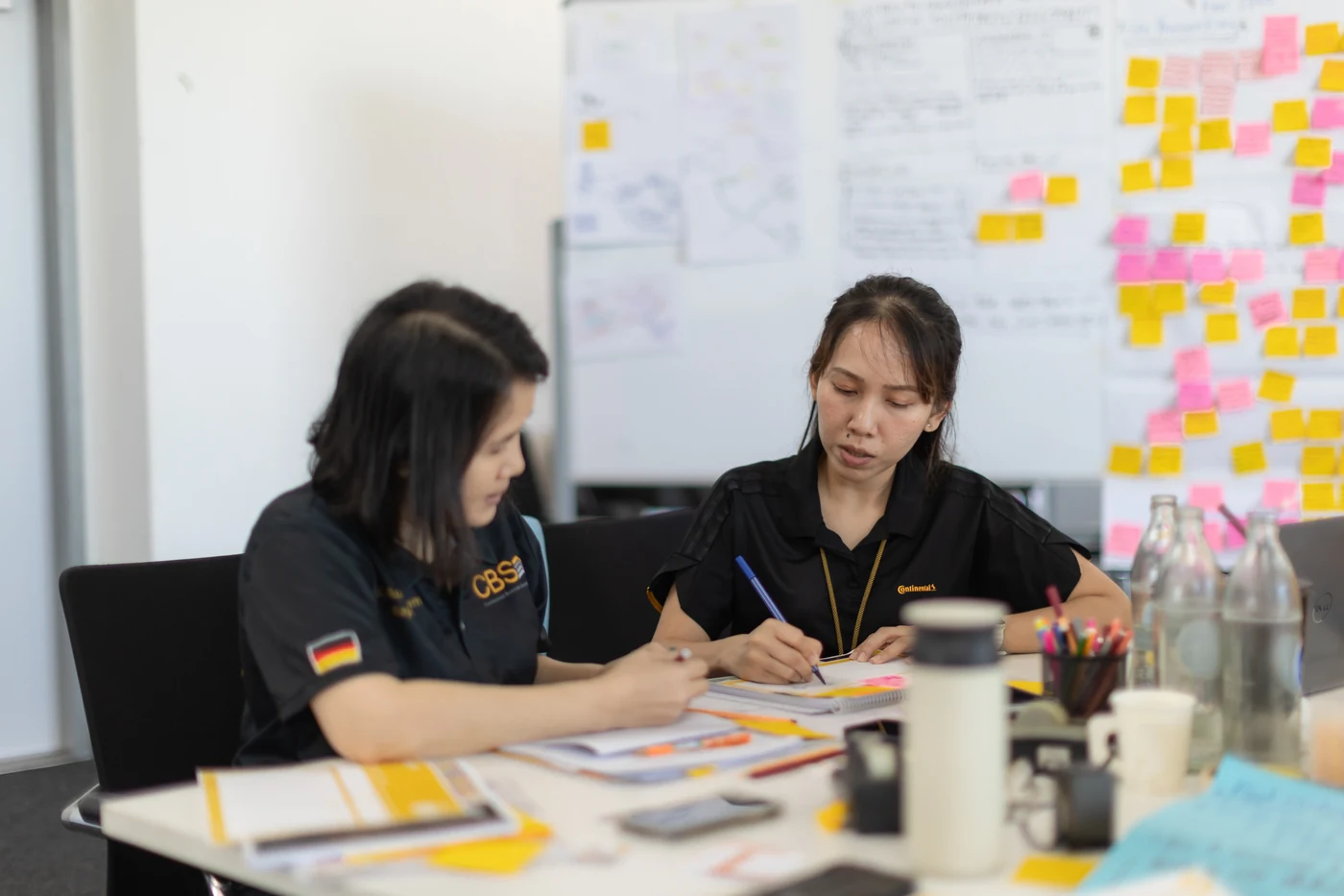 Two Continental trainees working on worksheets at the table