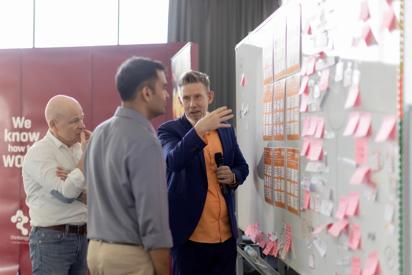Dr. D and Continental managers in front of an idea wall during the facilitator training