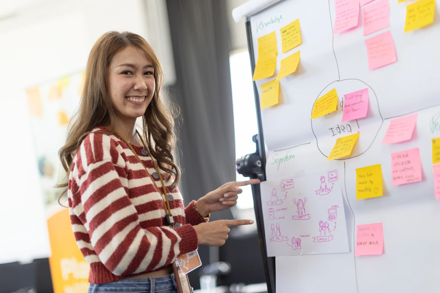 A smiling Continental trainee pointing at her team’s flipchart