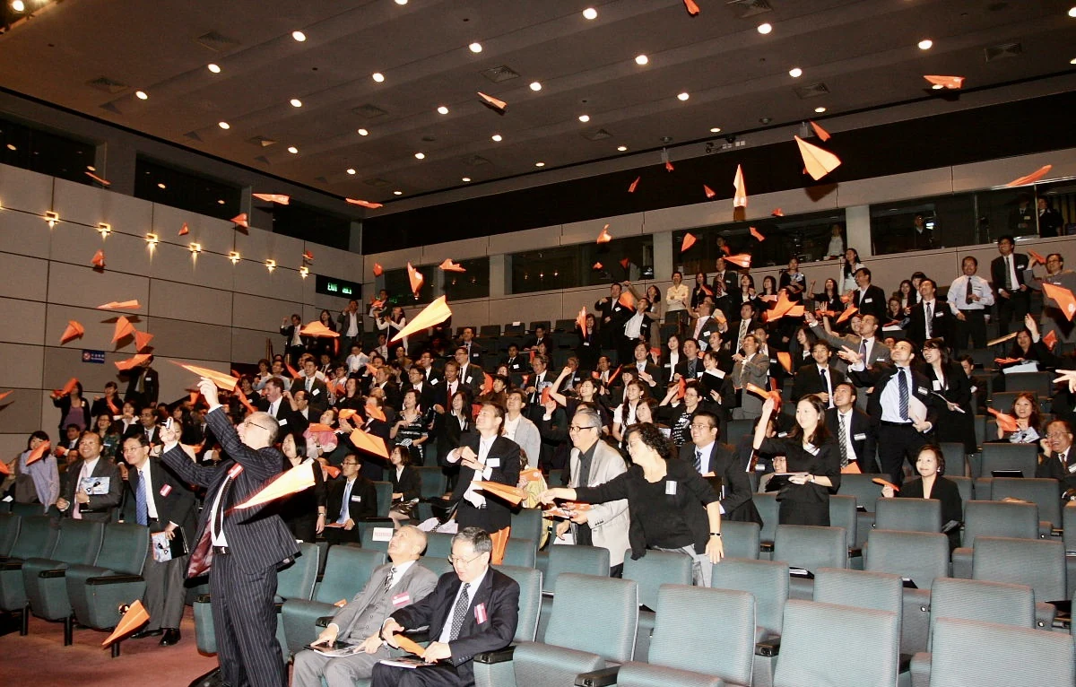 Audience at the Hong Kong Management Association conference launching paper planes during Dr. D's keynote