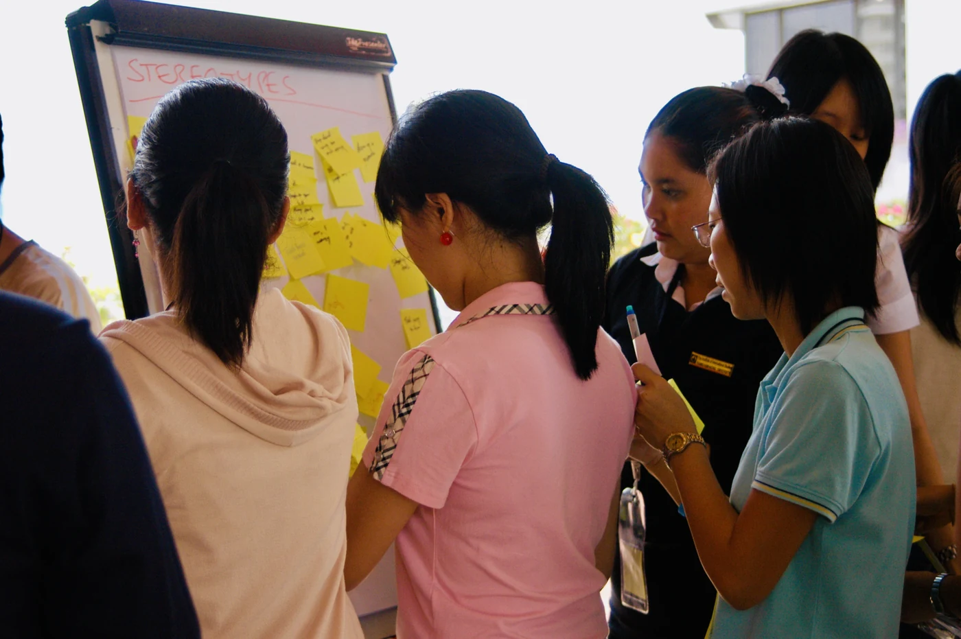 Participants adding sticky notes with ideas to a flipchart