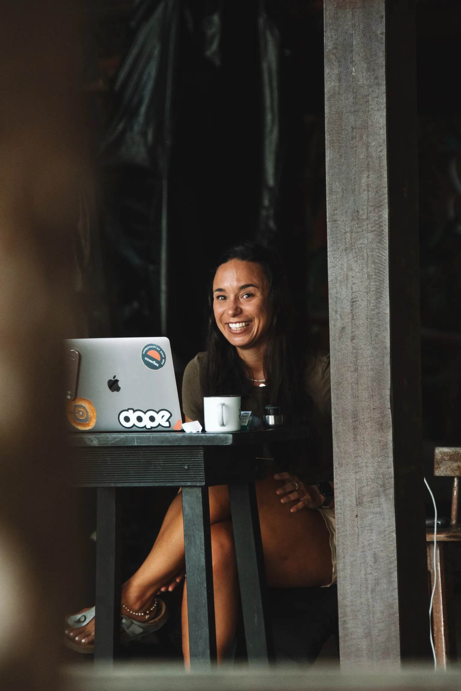 Digital nomad woman working on a laptop in a rustic workspace