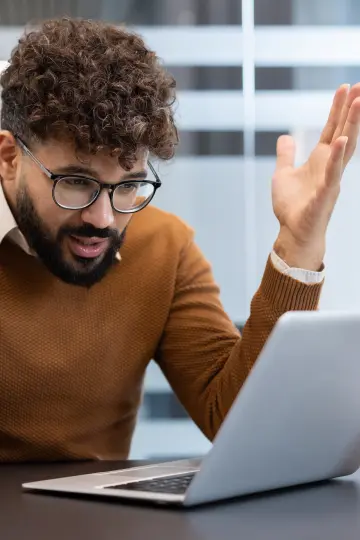 Man at laptop looking confused