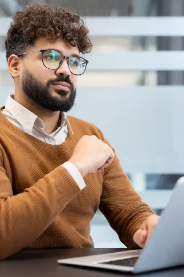 Man at laptop looking doubtful