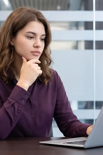 Woman at laptop looking doubtful