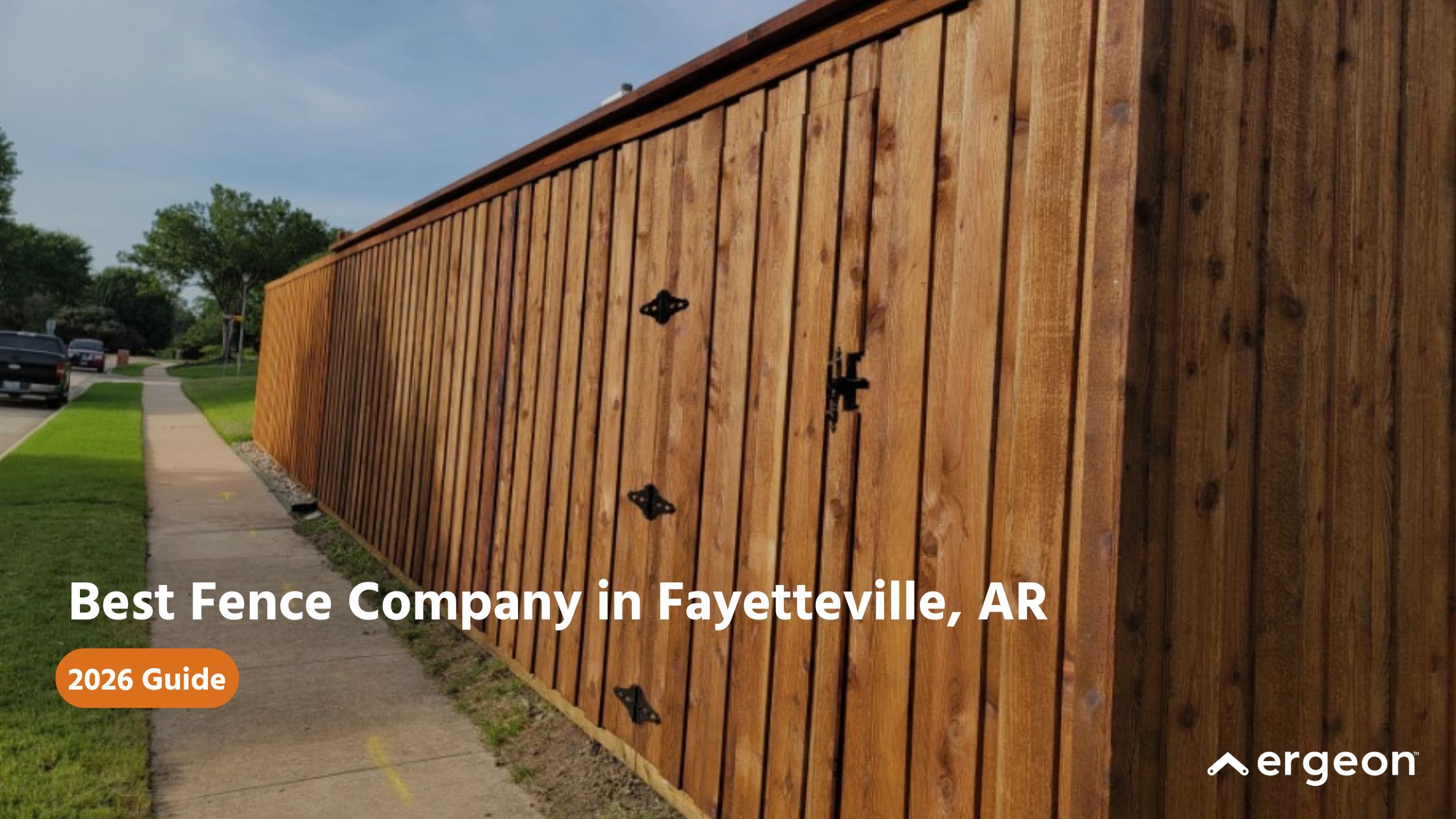 Best Fence Company in Fayetteville, AR - 2026 Guide This image showcases a high-quality wooden privacy fence installed along a suburban sidewalk in Fayetteville, Arkansas. The fence is constructed with vertical wooden planks and features decorative black hinges on a fenced gate. The image highlights the craftsmanship and aesthetic appeal of the fence, suggesting it as an example of top fencing work available in Fayetteville. This image is suitable for a guide or directory featuring reliable fencing companies in the Fayetteville area for the year 2026.