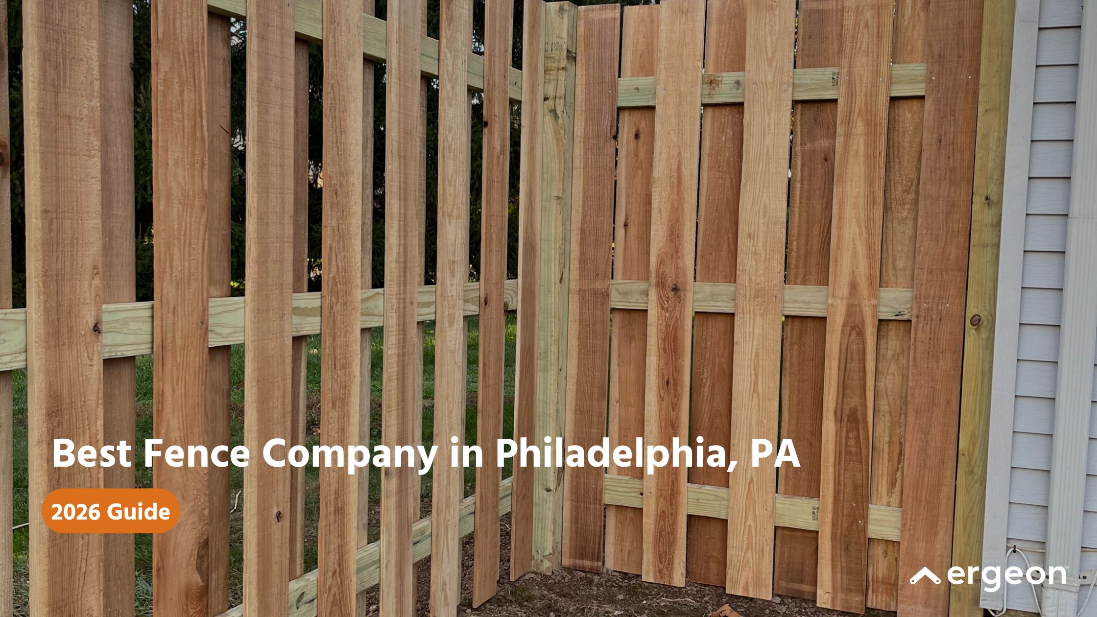 This image showcases a newly constructed wooden fence with vertical panels in a residential backyard setting. The text overlay promotes a guide for the best fence company in Philadelphia, Pennsylvania for the year 2026. The image highlights the craftsmanship and materials used in fence installation, suitable for marketing or informational use in home improvement and landscaping contexts. The branding 'ergeon' is visible, indicating the likely source or publisher of the guide.