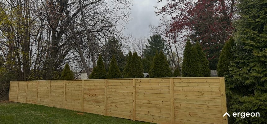Wooden Privacy Fence with Evergreen Trees in Backyard