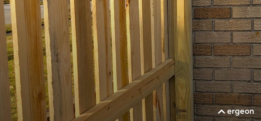 Close-Up View of Wooden Fence Adjacent to Brick Wall