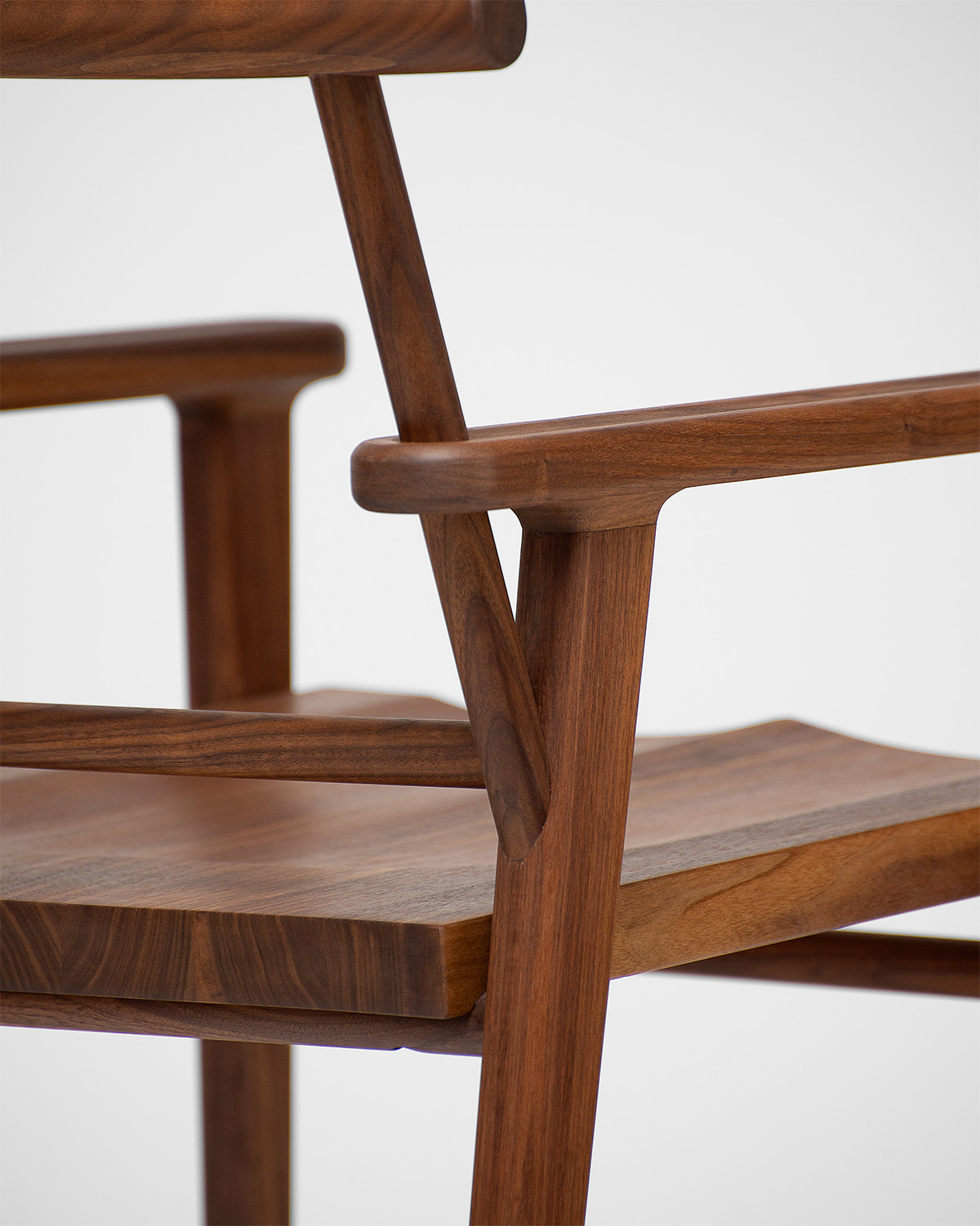 Vue rapprochée de la structure et des accoudoirs d’une chaise en bois photographiée pour l’École d’ébénisterie d’art de Montréal.