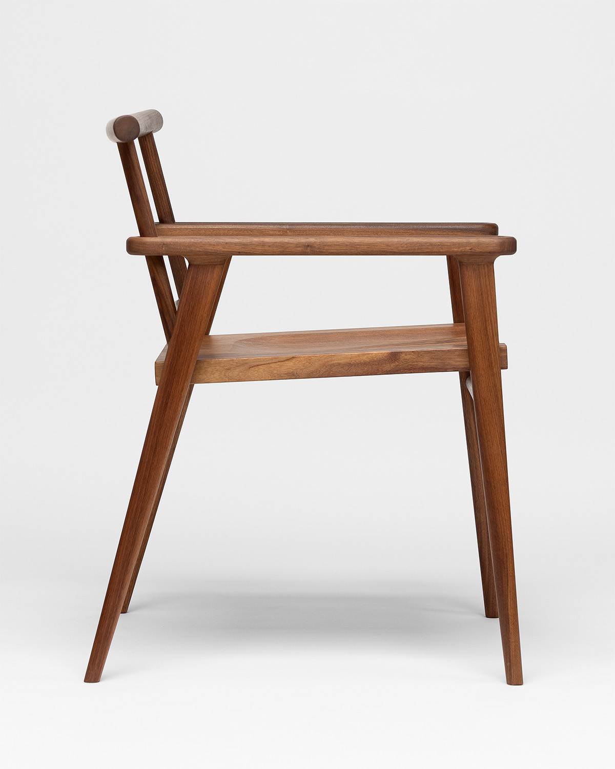 Chaise en bois vue de profil sur fond blanc, photographiée pour l’École d’ébénisterie d’art de Montréal.