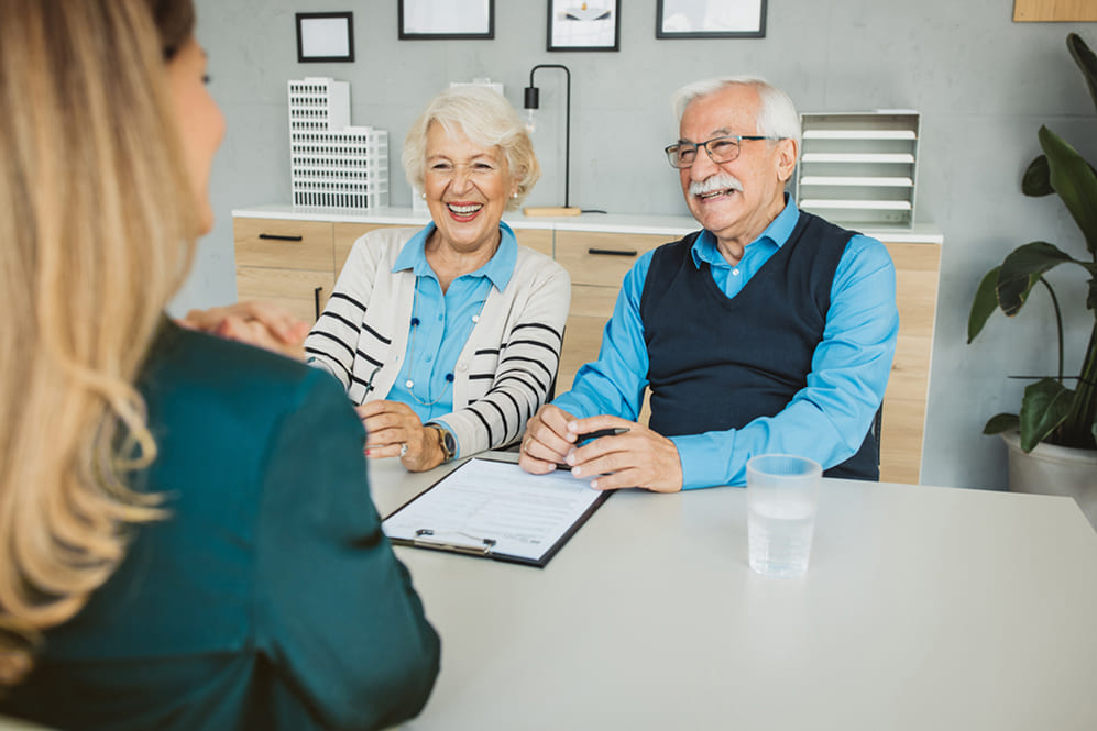 Smiling senior couple meeting with a dental consultant to review denture insurance and Canadian Dental Care Plan (CDCP) coverage options