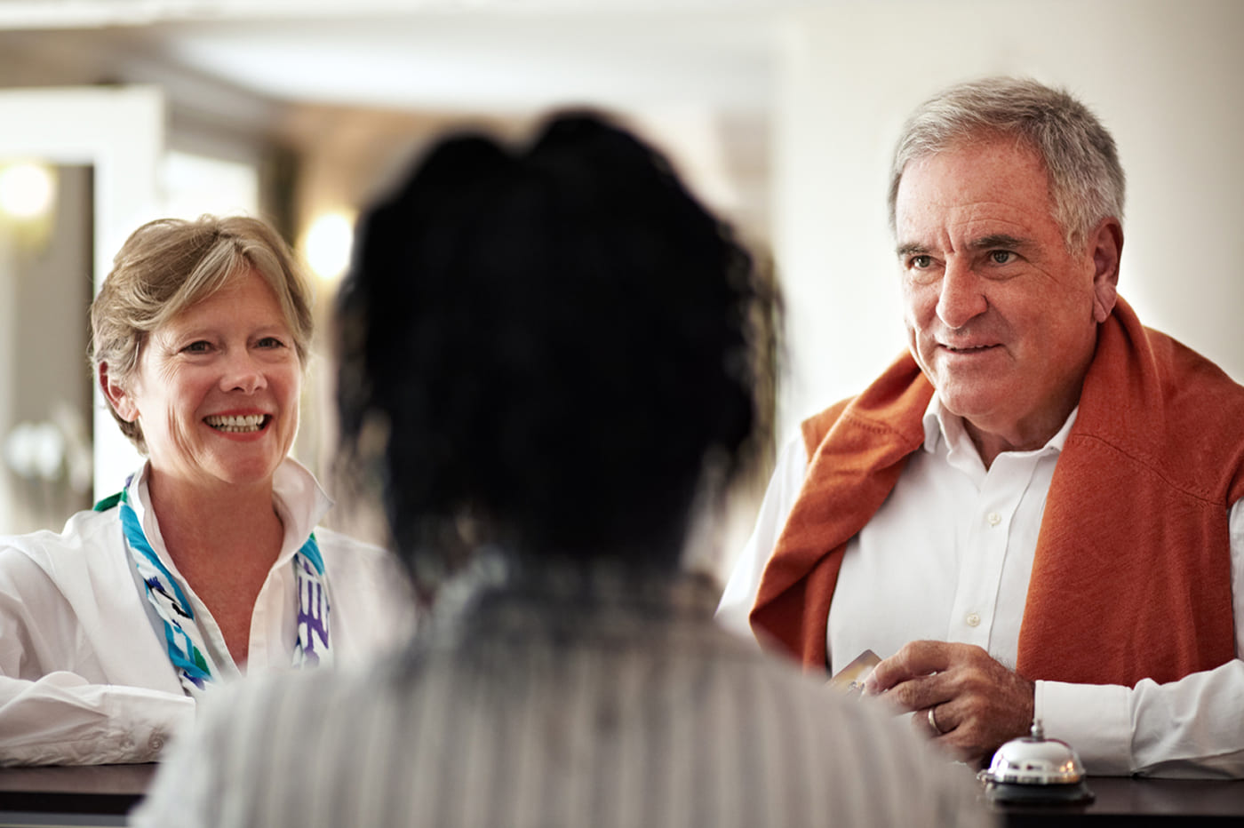 Smiling senior couple speaking with a denture clinic receptionist during their first consultation