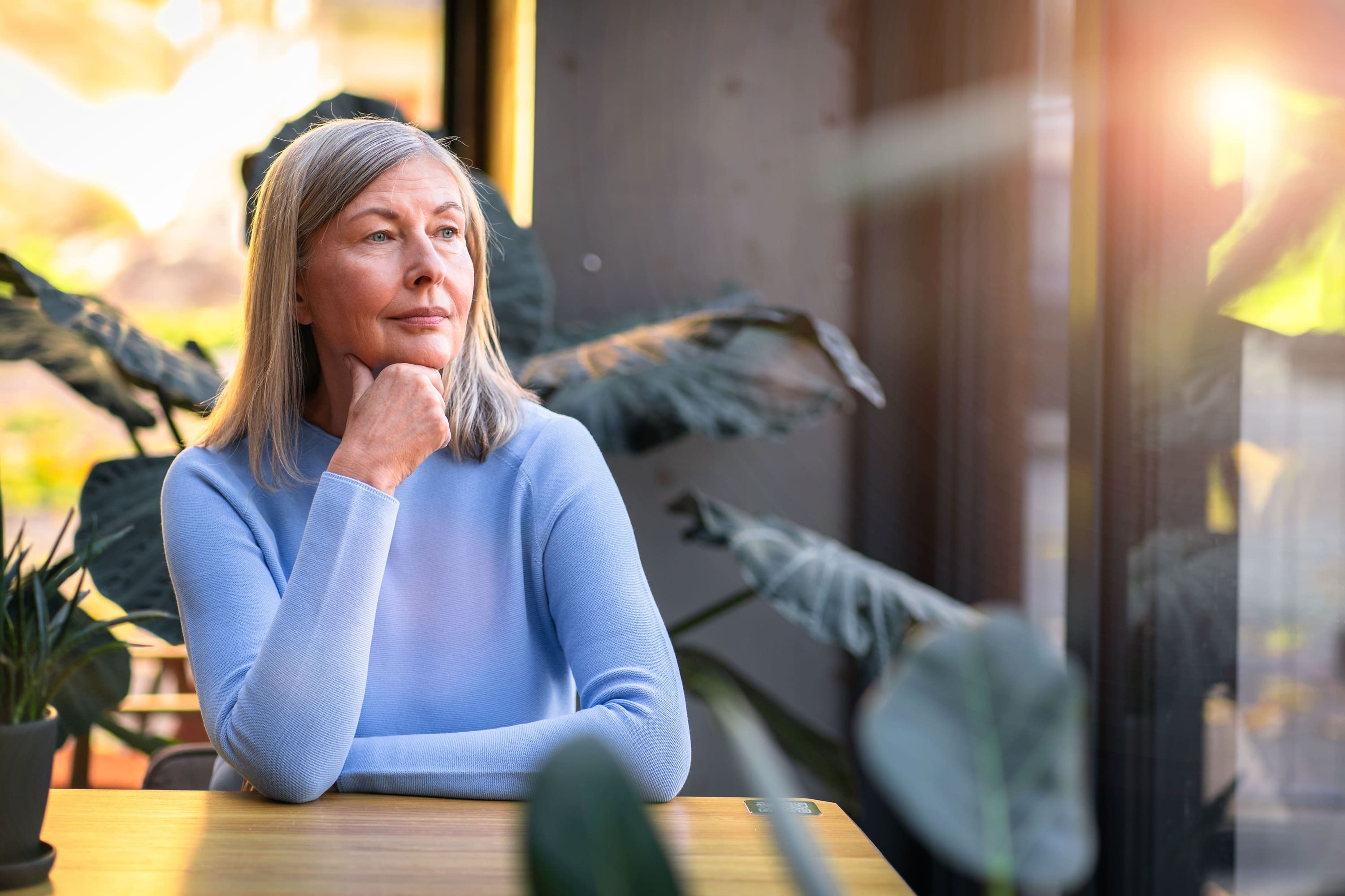 Mature woman thoughtfully considering her denture options after full tooth extractions