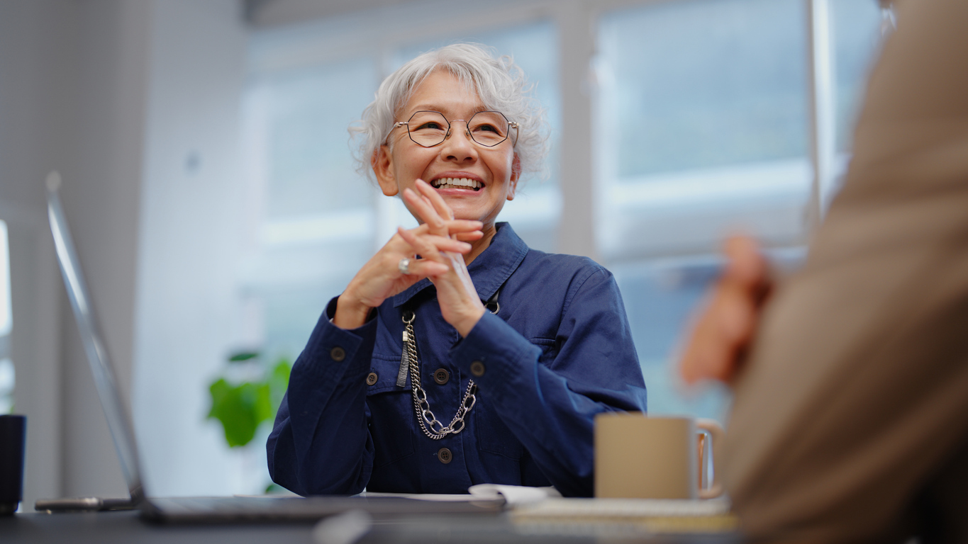 Confident senior female patient with a bright smile discussing dental care with her attentive female dentist in a warm, inviting clinic setting, reflecting positive patient experiences with Saberton dental services.