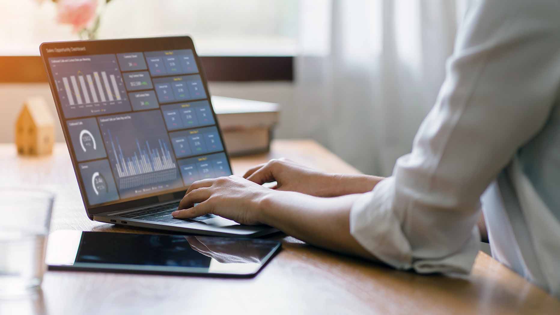 ACO leader examining data analytics dashboard on laptop