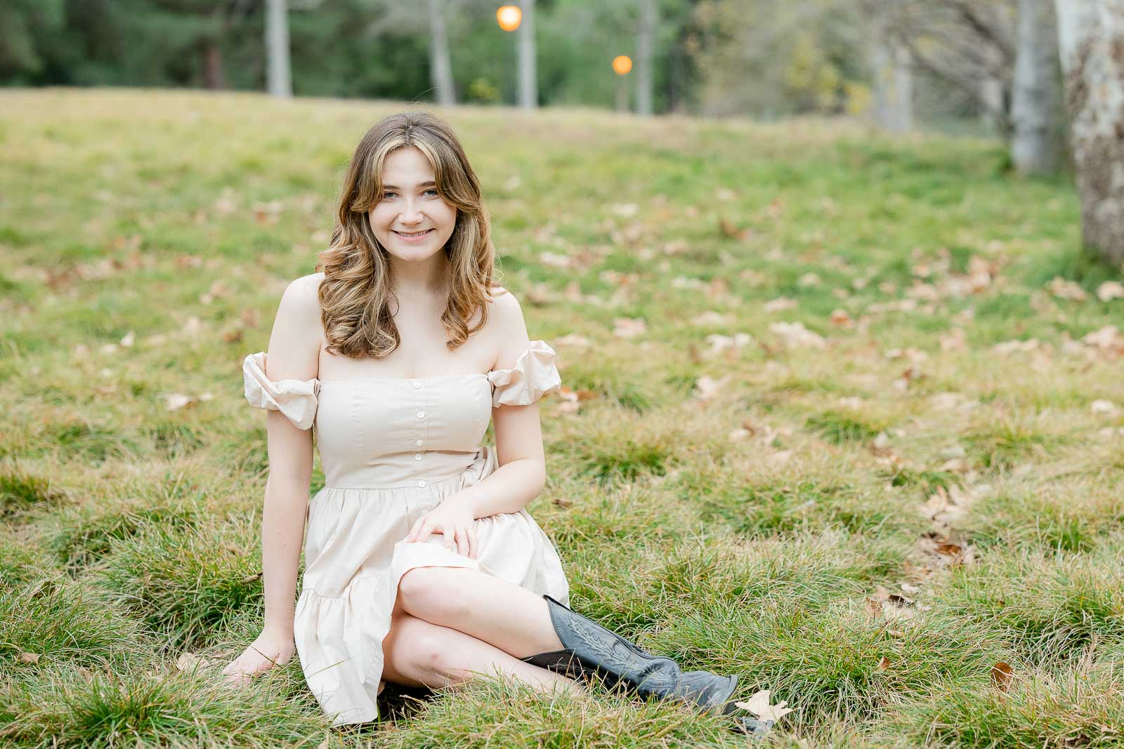 senior photo girl sitting with short dress in a field