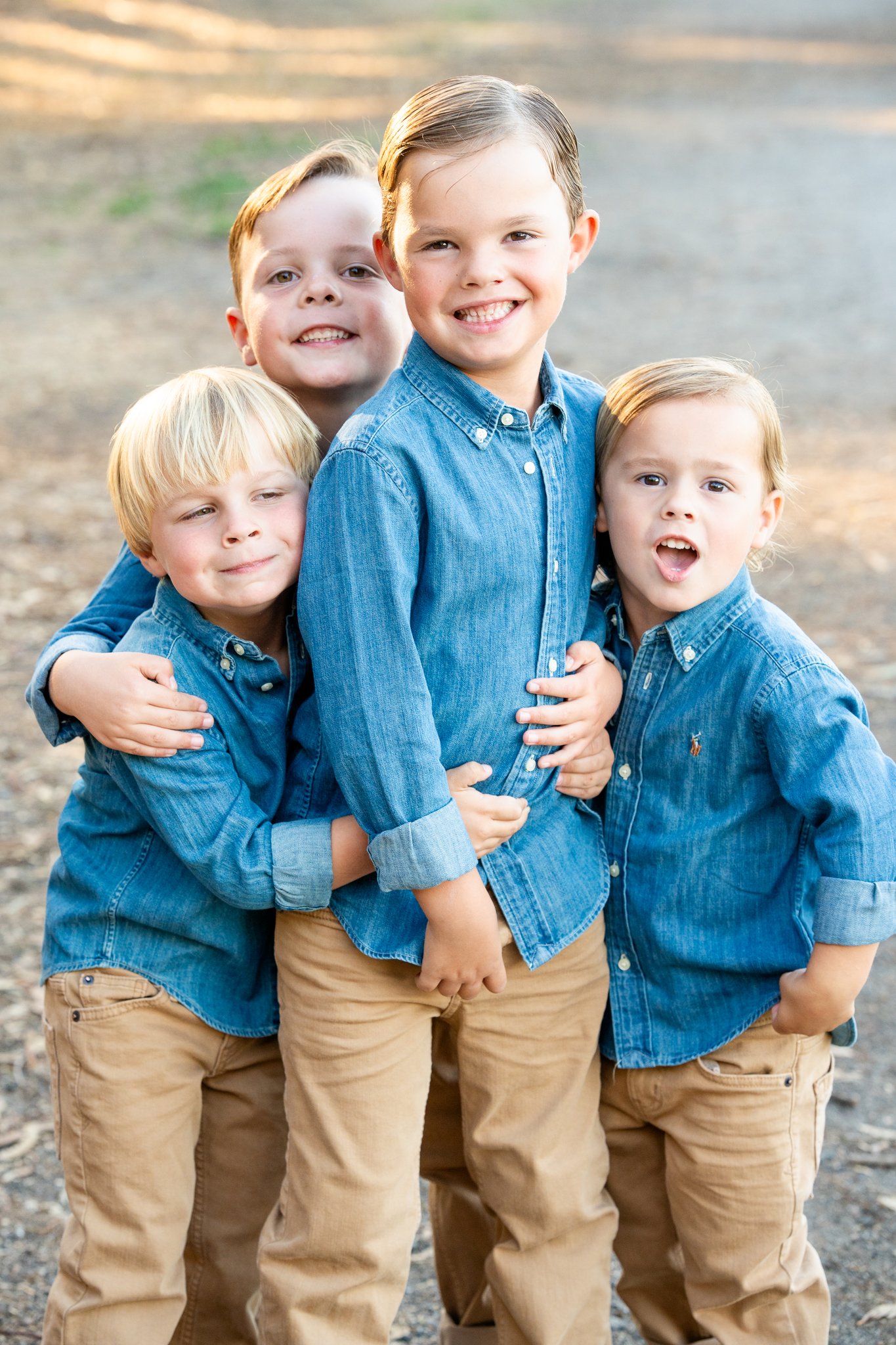 four little boys between ages 2 and 5 playing at a family photo session at gum grove park in seal beach