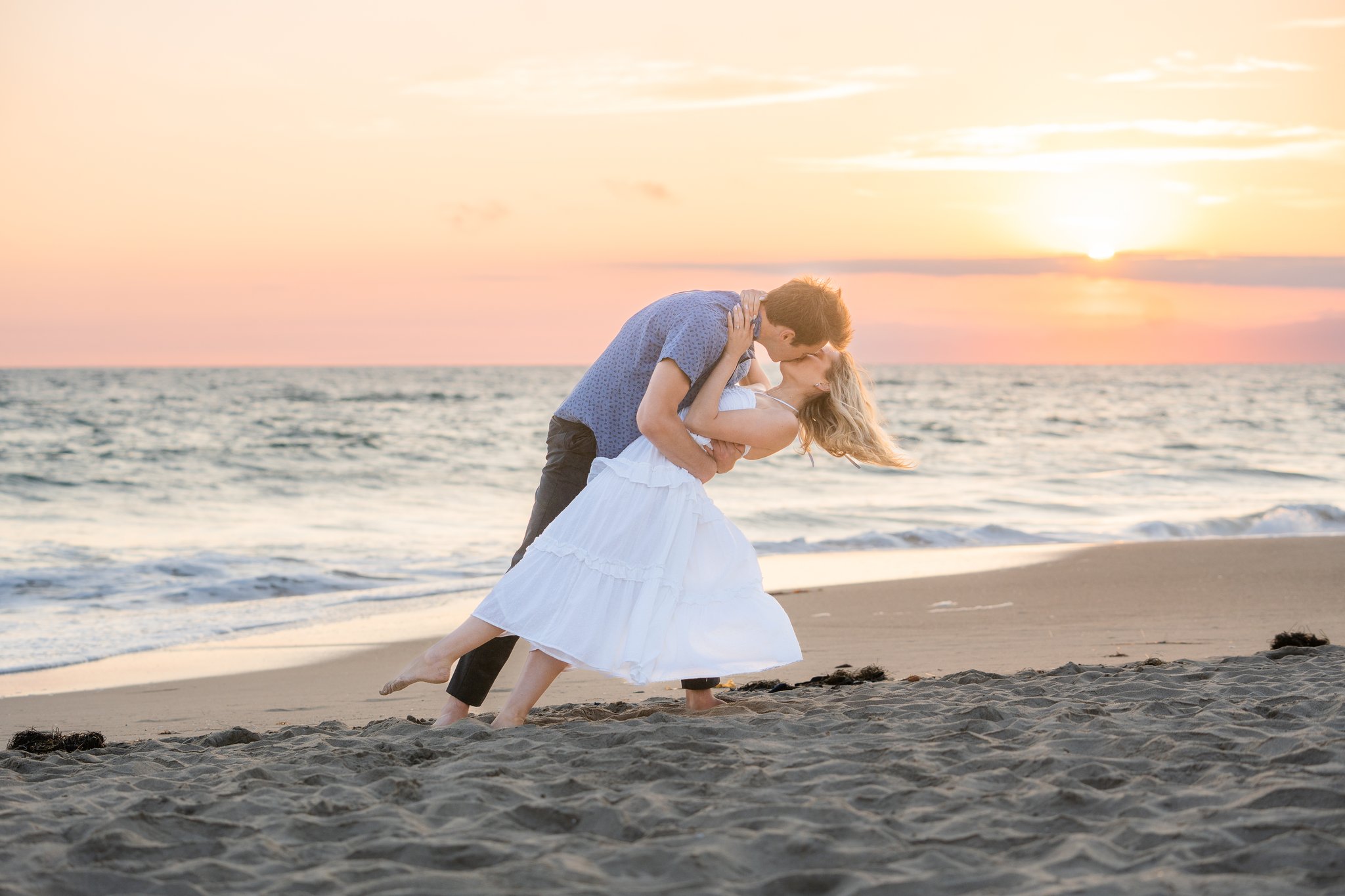 santa monica engagement session couple does a perfect dip on the beach during sunset.