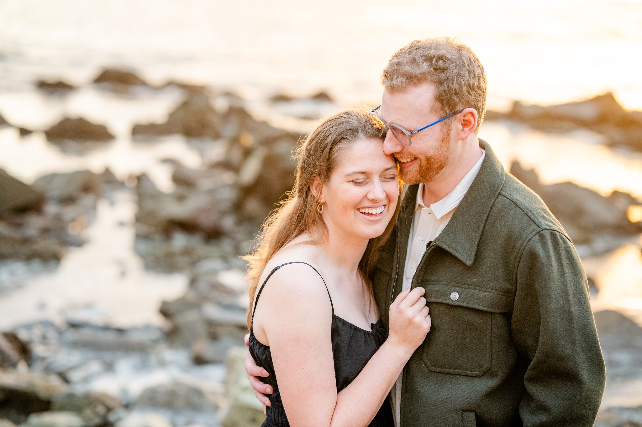couple laughing at the beach during engagement session