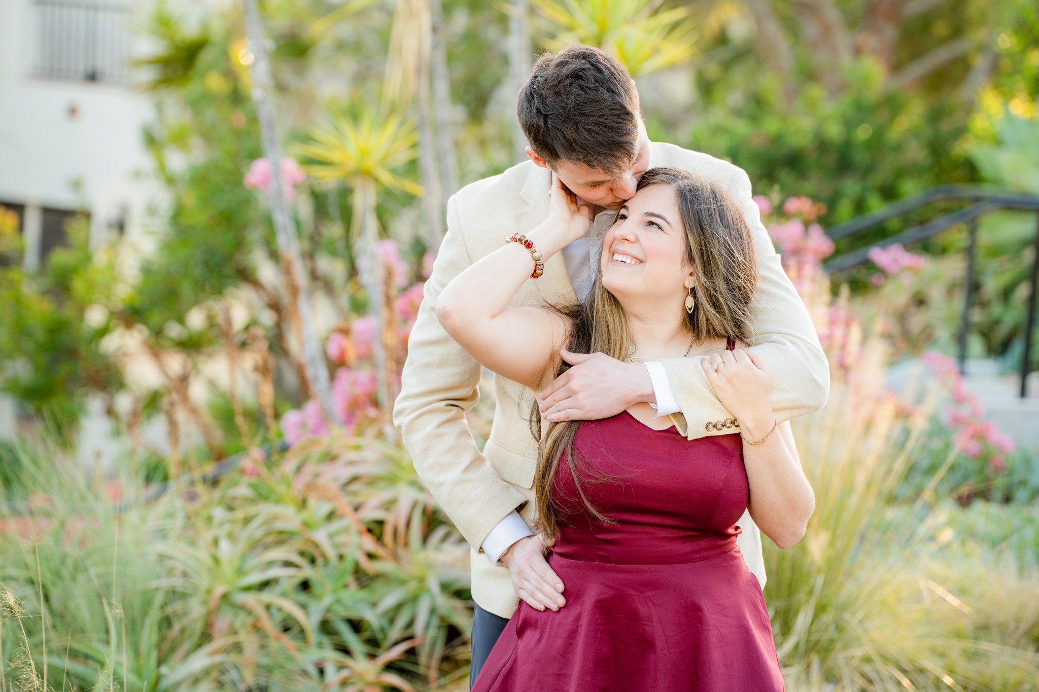 engagement photos couple in burgundy dress in flower garden