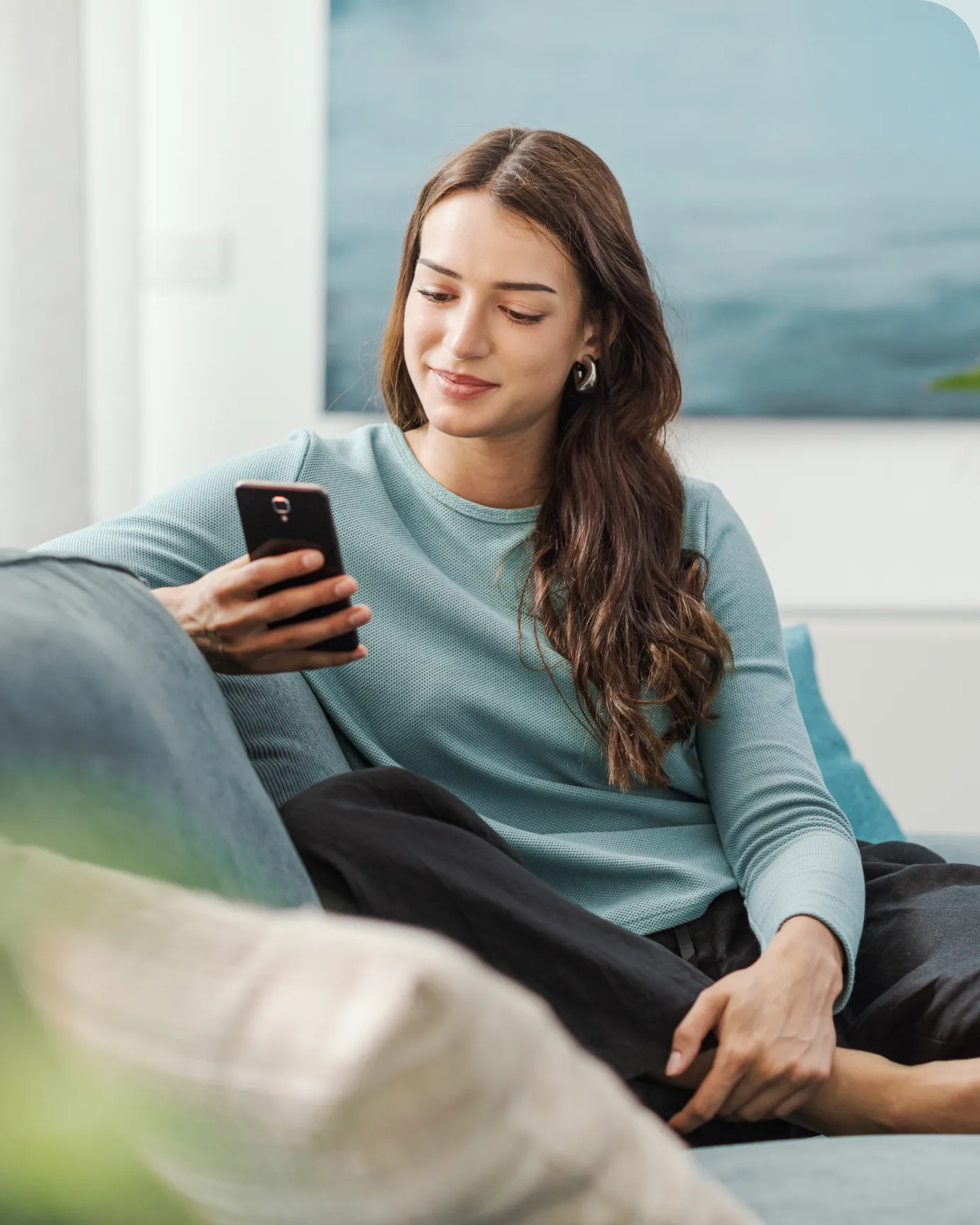 Mujer en el sofá consultando el móvil