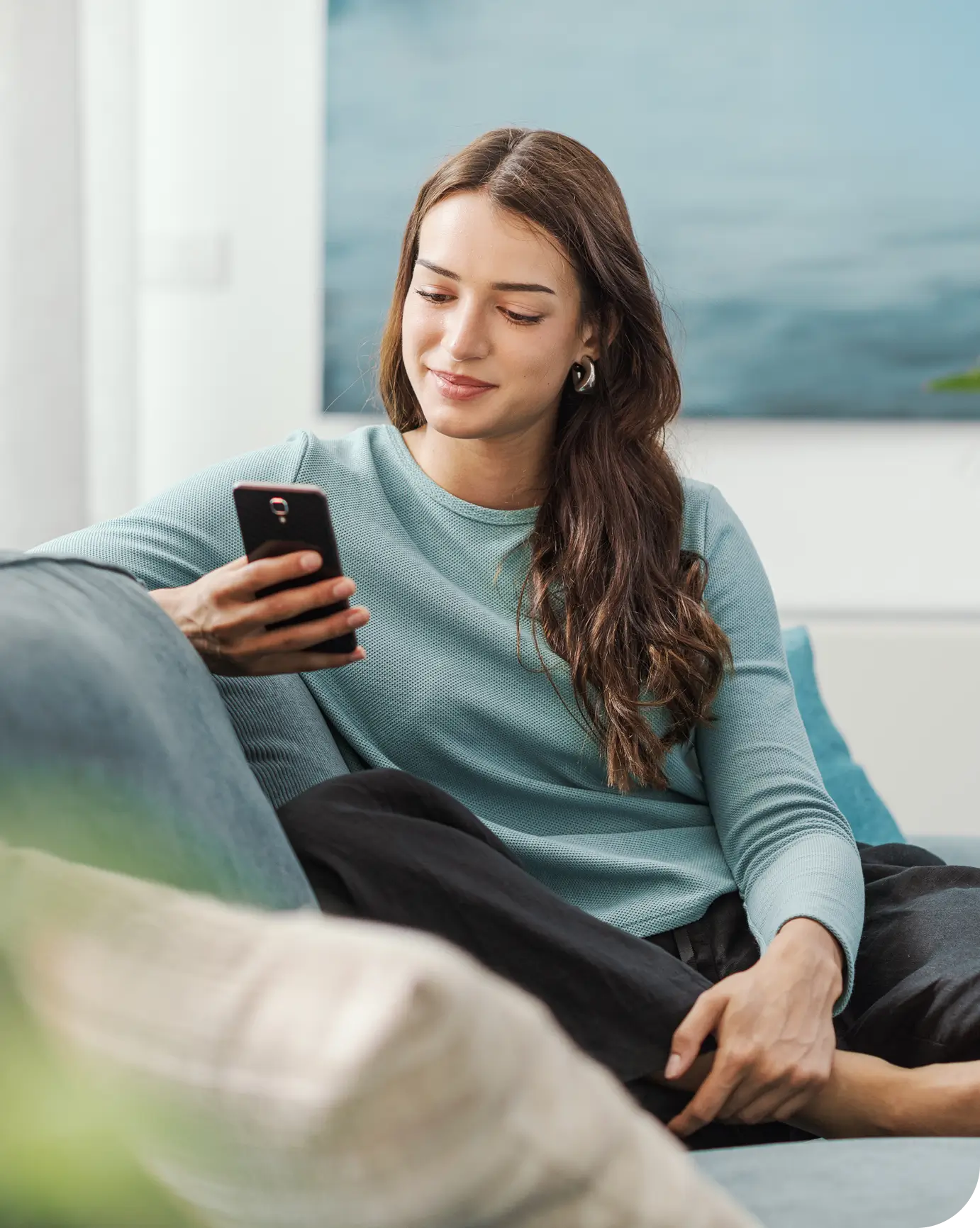 Mujer en el sofá consultando el móvil
