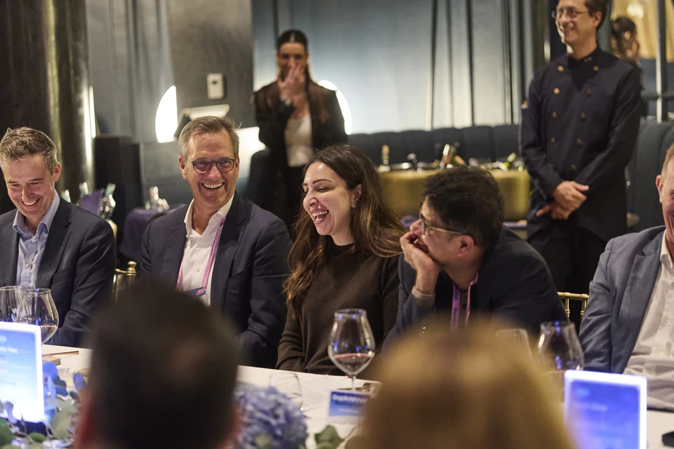 Des invités rient et réagissent à une expérience de mentalisme pendant un dîner.