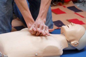 A person performing CPR on a mannequin.