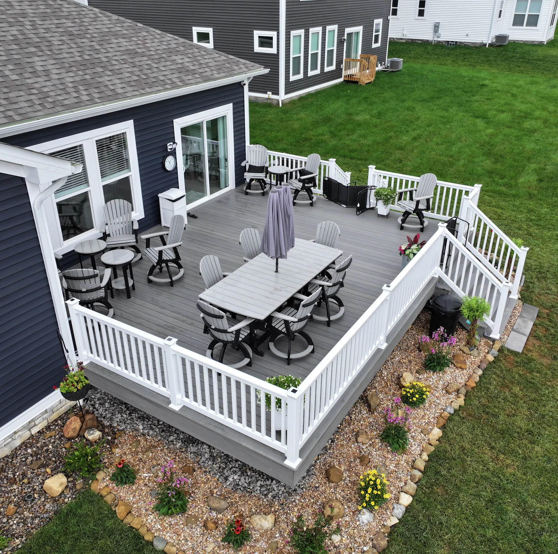 angled view of grey deck with white railings in the backyard of a blue house in Pataskala Ohio