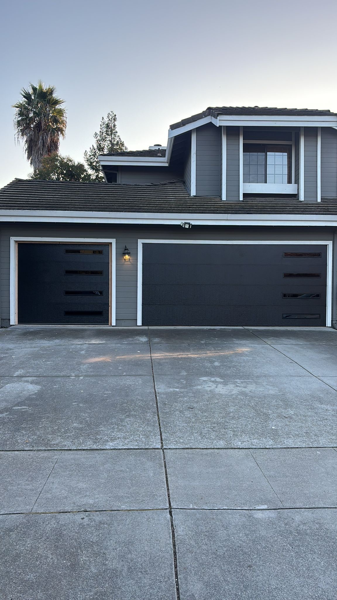 A light gray house with a dark gray garage door in Redwood City