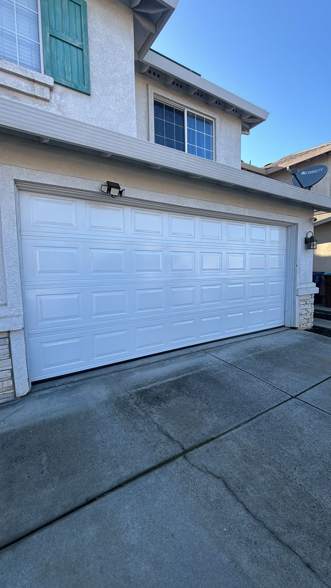 A light gray house with a dark gray garage door in Redwood City