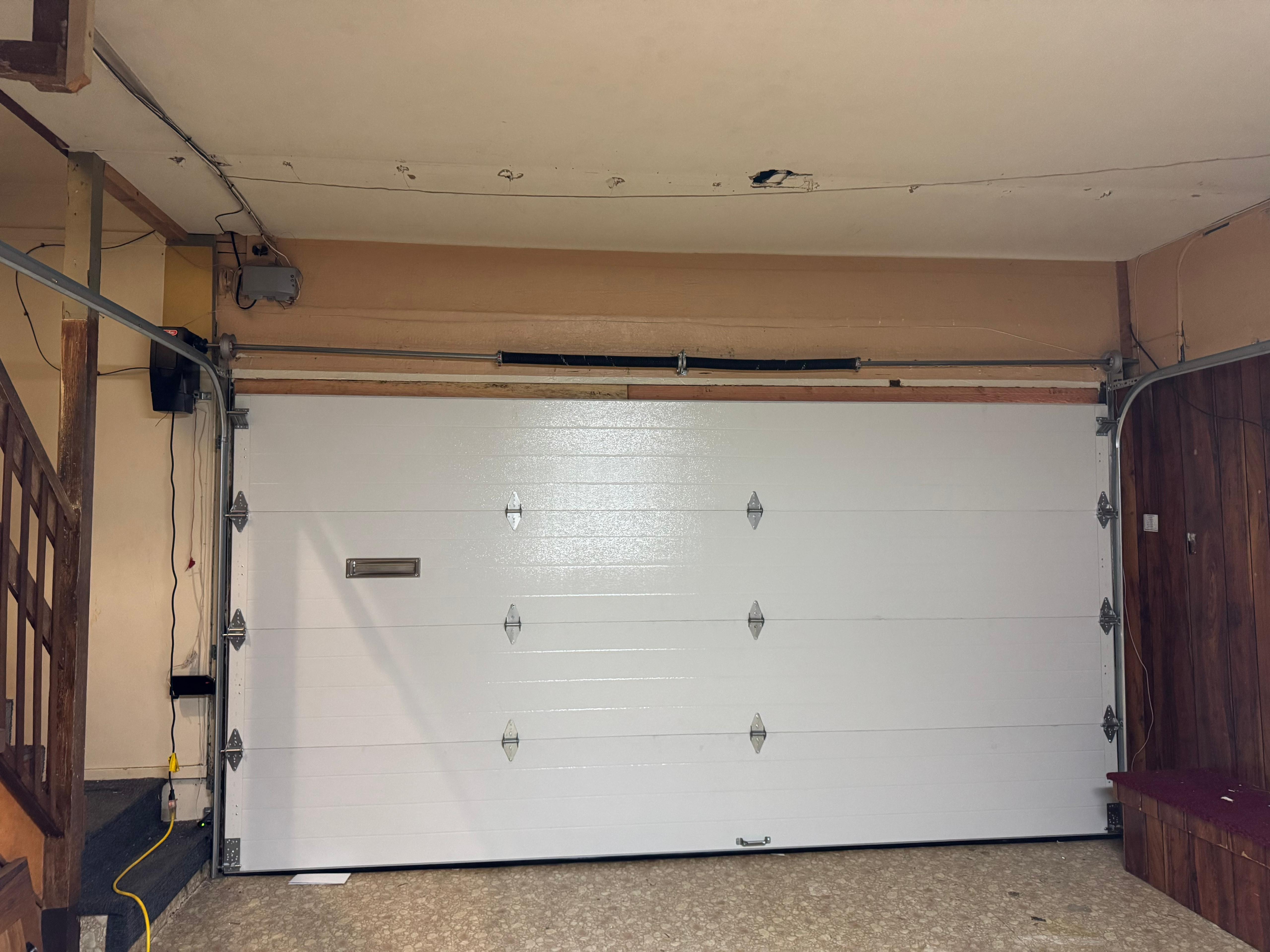 The inside of a garage with a new, white garage door