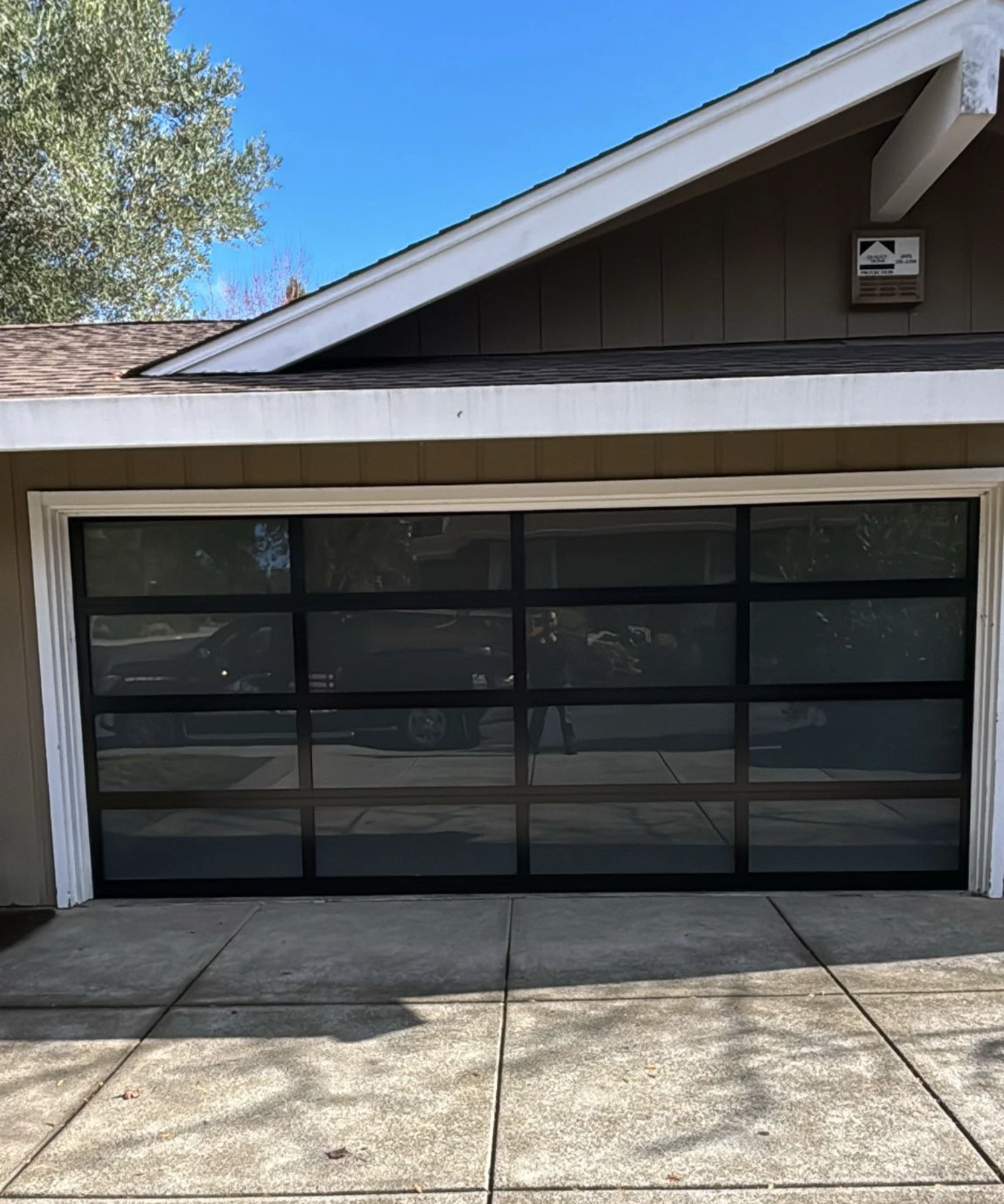 A brown house with a paneled garage door