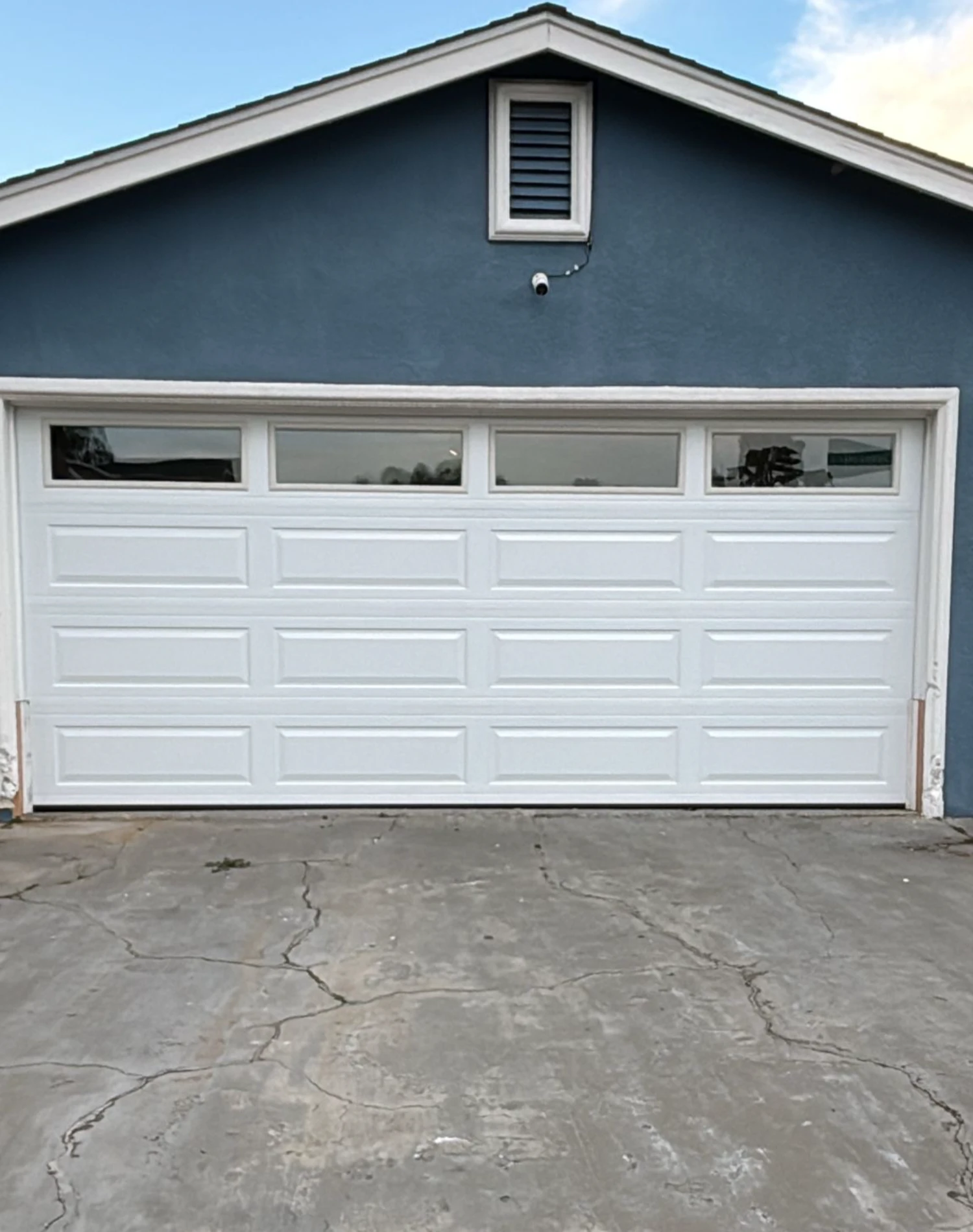A blue house with a white garage door