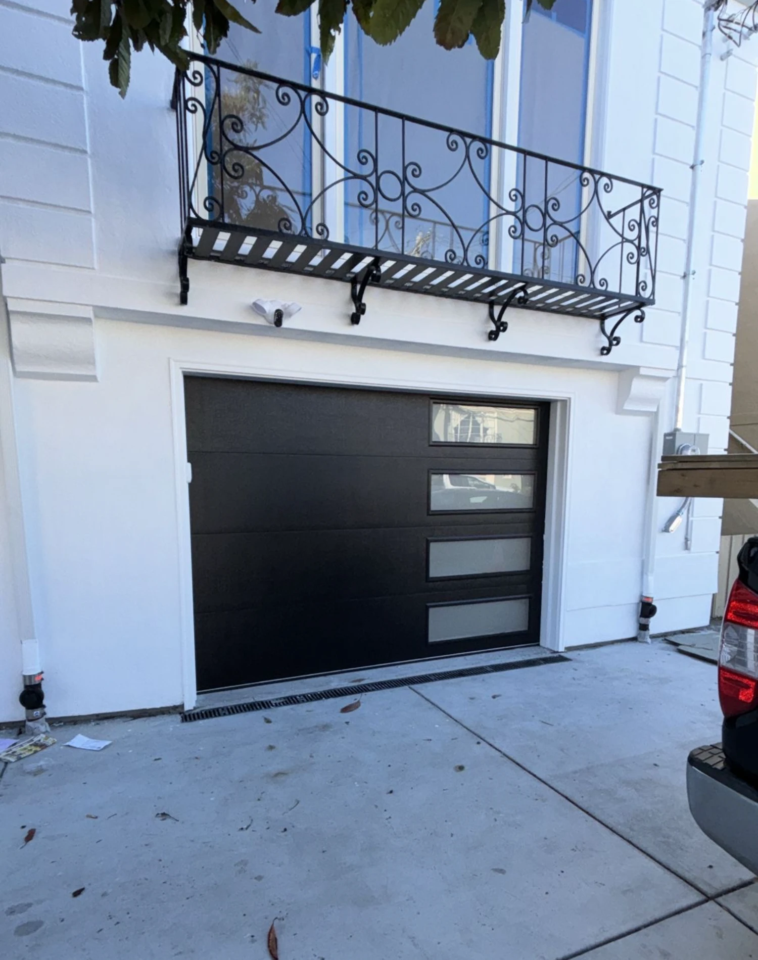 A white house with a dark brown, modern garage door