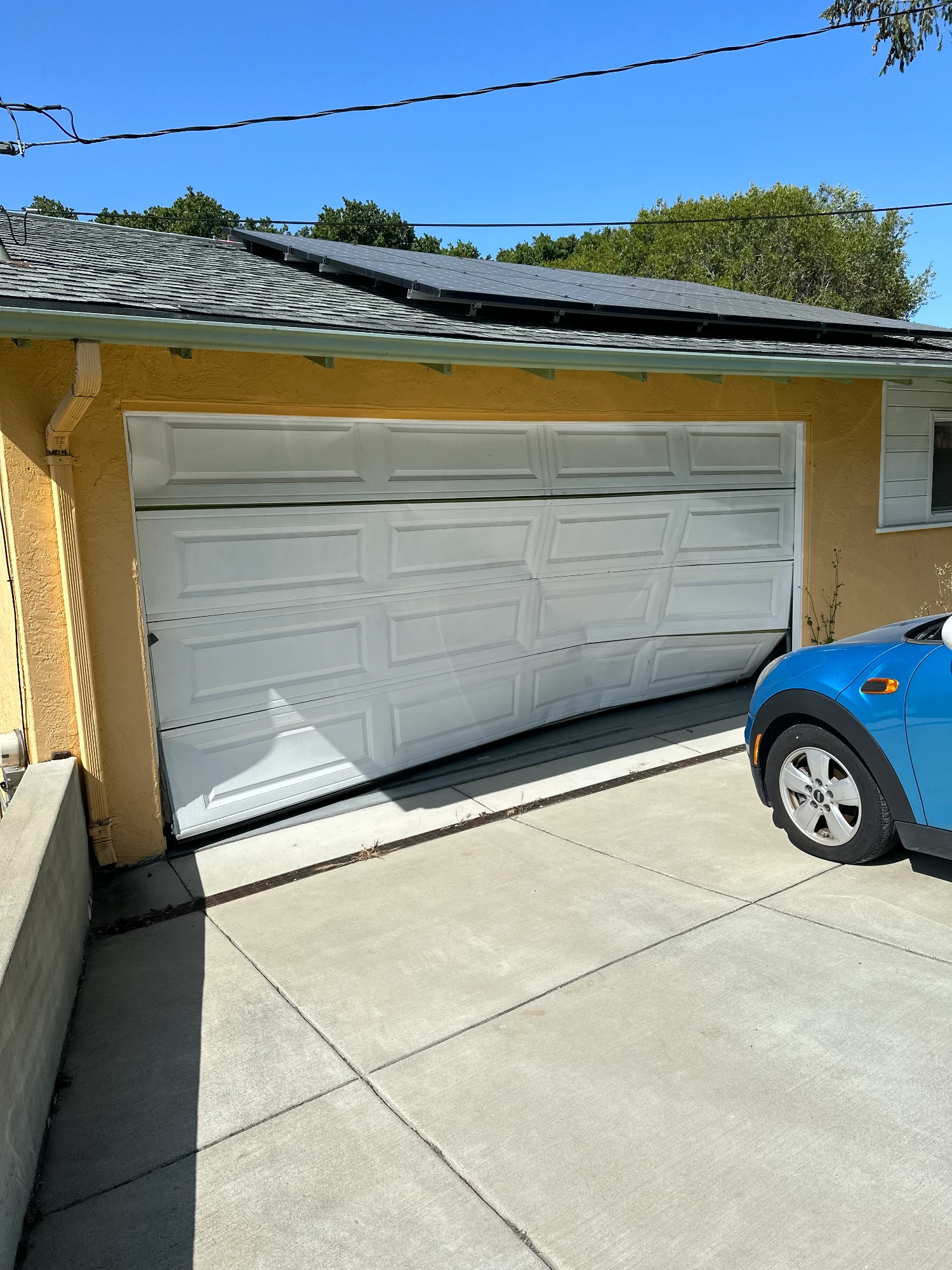 A home with a damaged white garage door