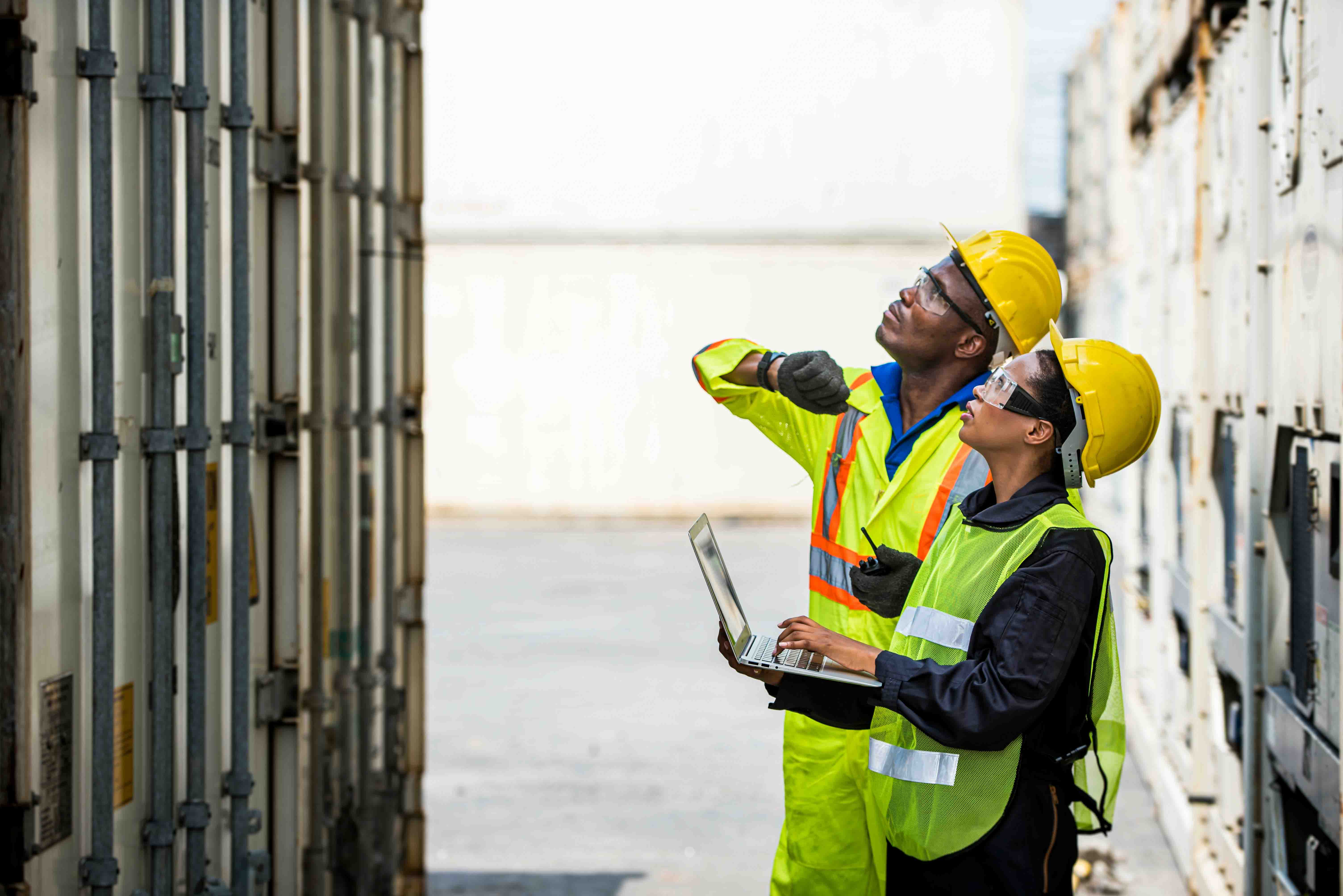 Man and woman in high vis jackets inspecting a shipment