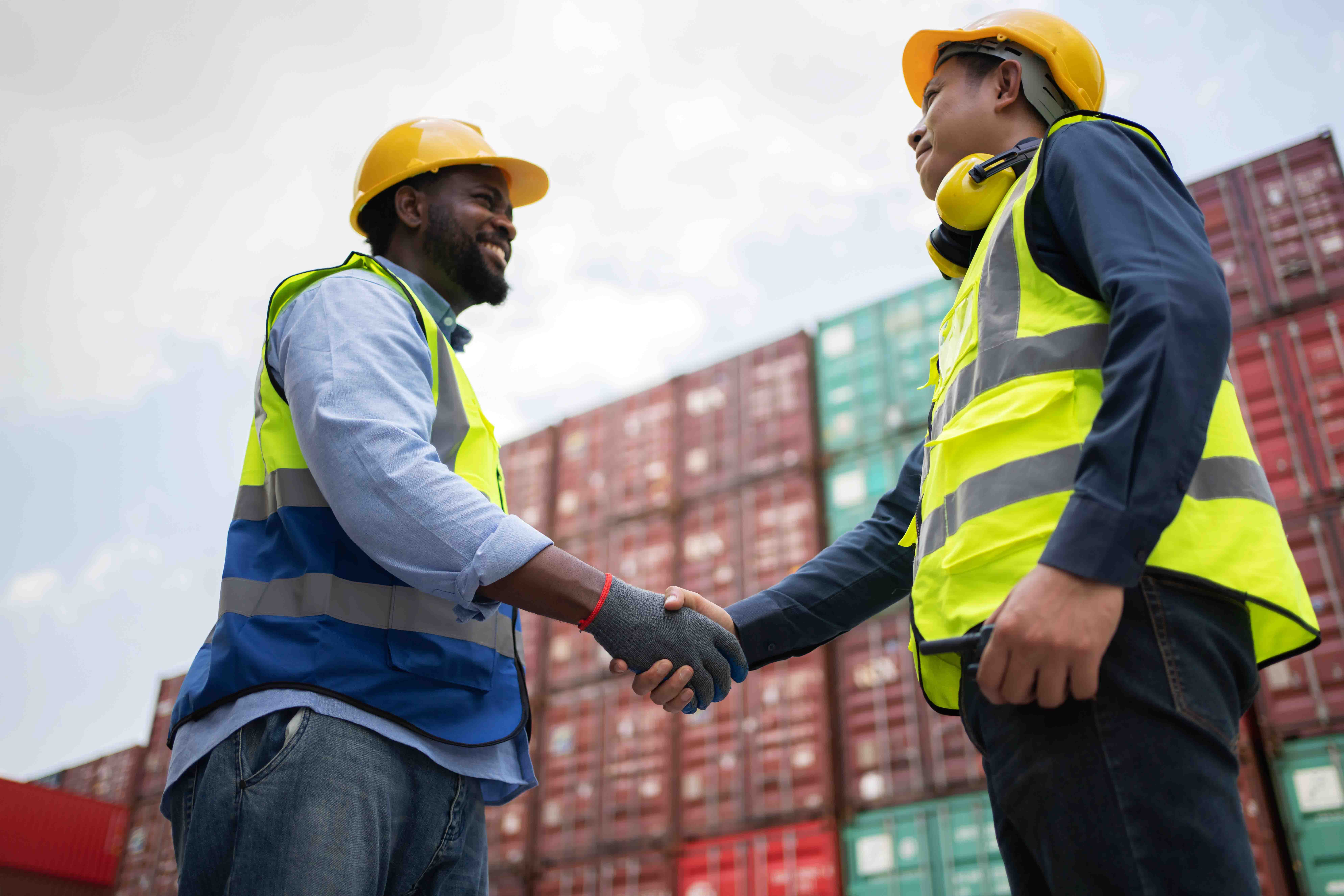 Man in a high vis jacket shaking hands with another worker