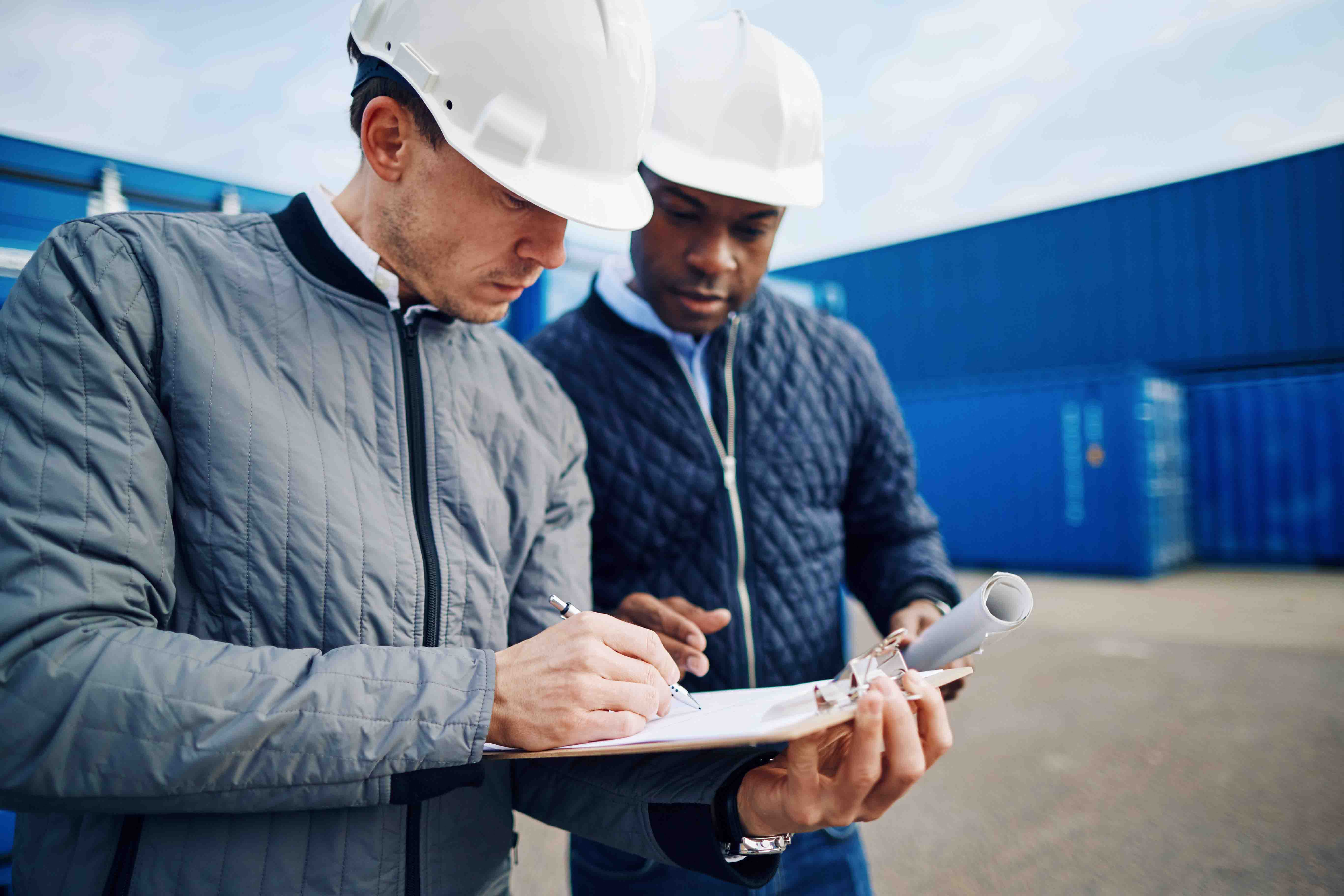 Two workmen checking a list