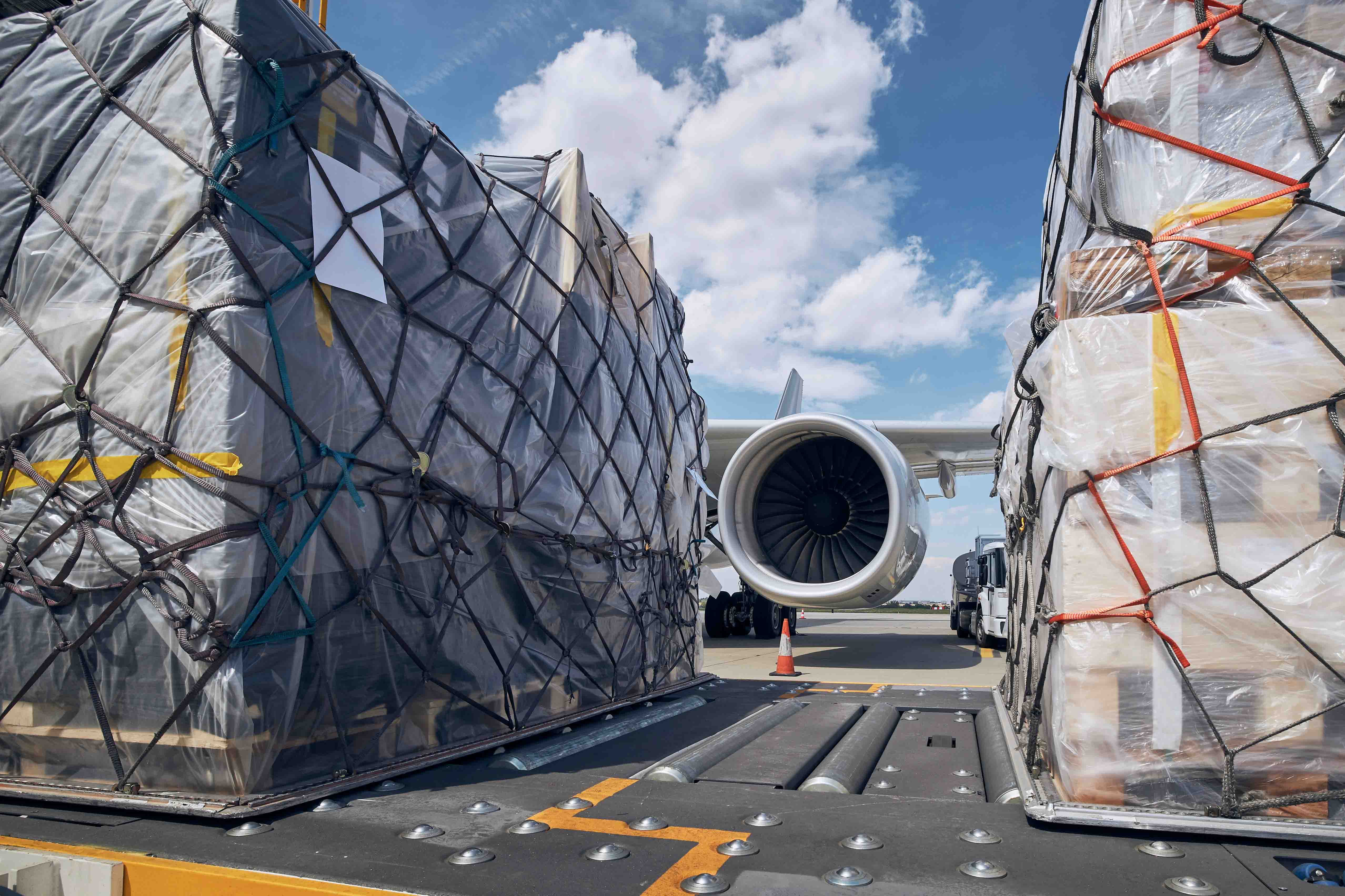 Two cargo palettes in front of a cargo plane engine