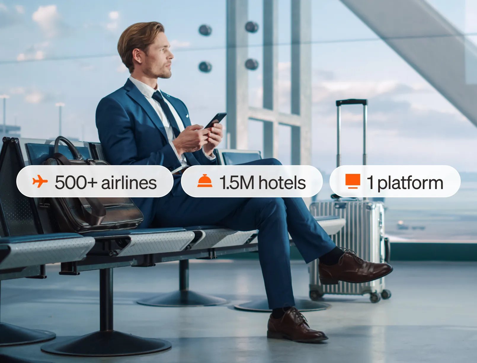 A man in a blue suit sits in an airport with luggage; travel service stats appear beside him: 500+ airlines, 1.5M hotels, 1 platform.