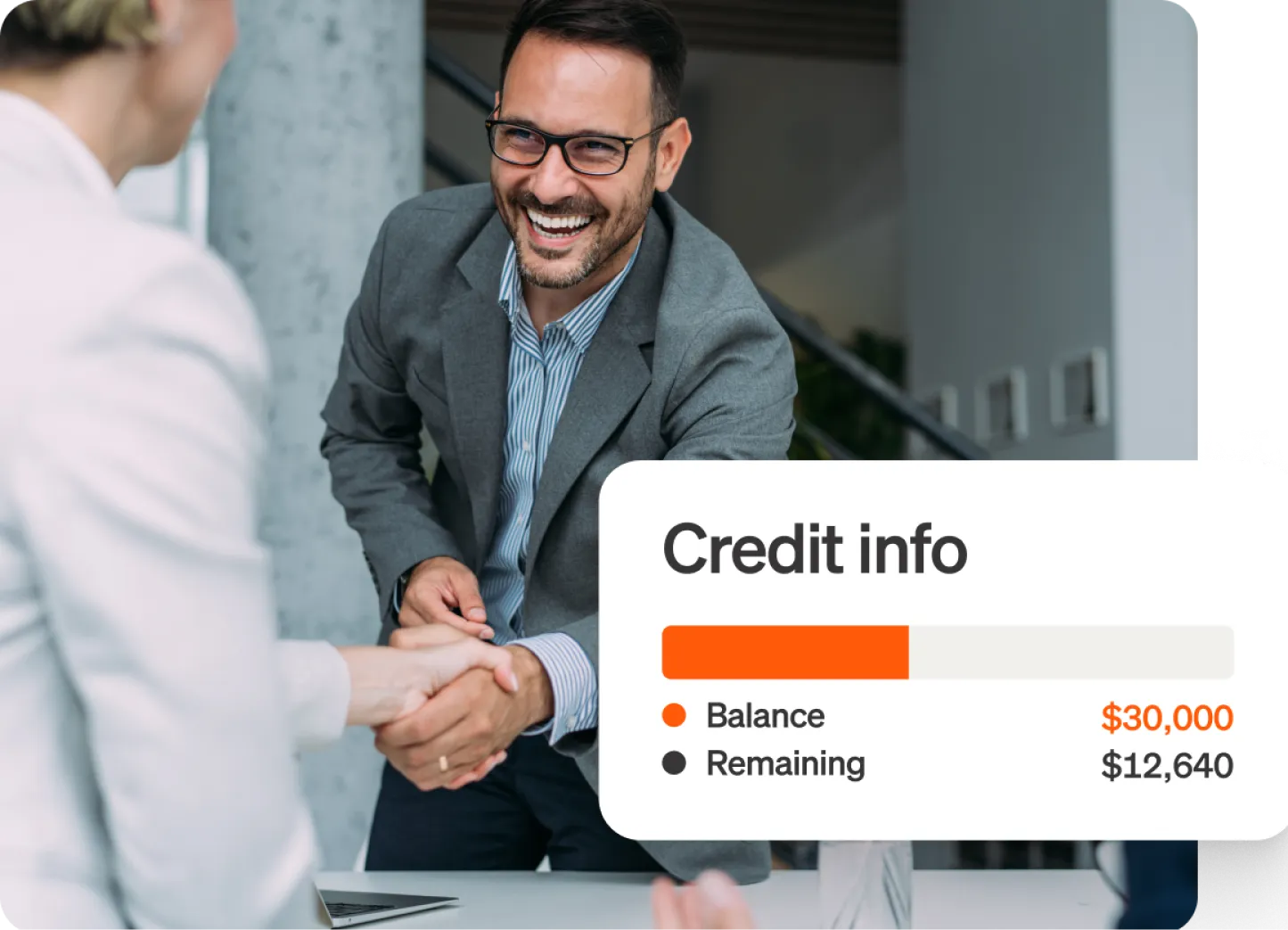 Smiling man in light blue shirt and grey blazer shakes hands with someone across a desk, notification for Credit ino showing a balance of $30,000 and Remaining $12,000 is shown overlaid.