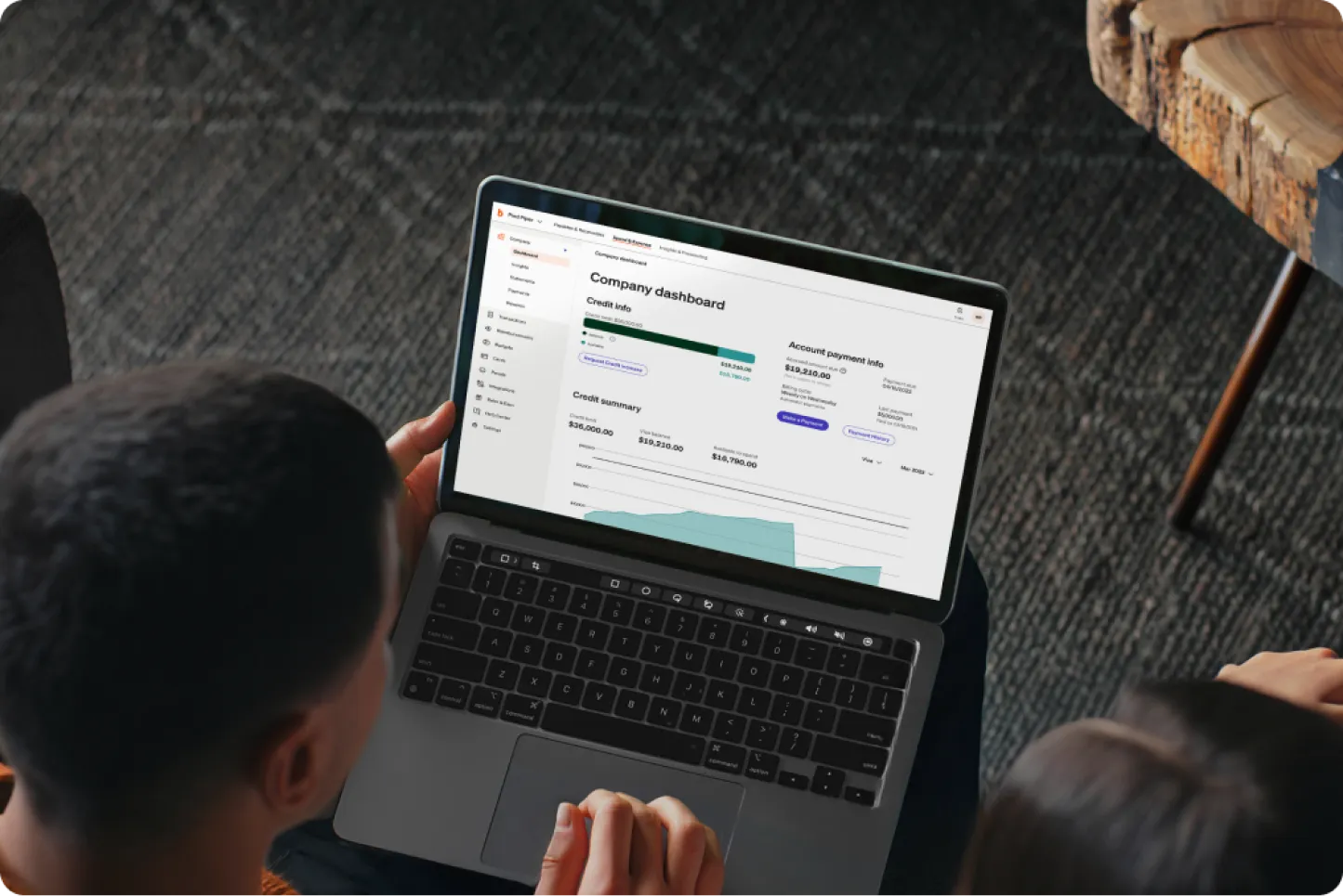 Two people look at a laptop showing a BILL dashboard in a moody dark room